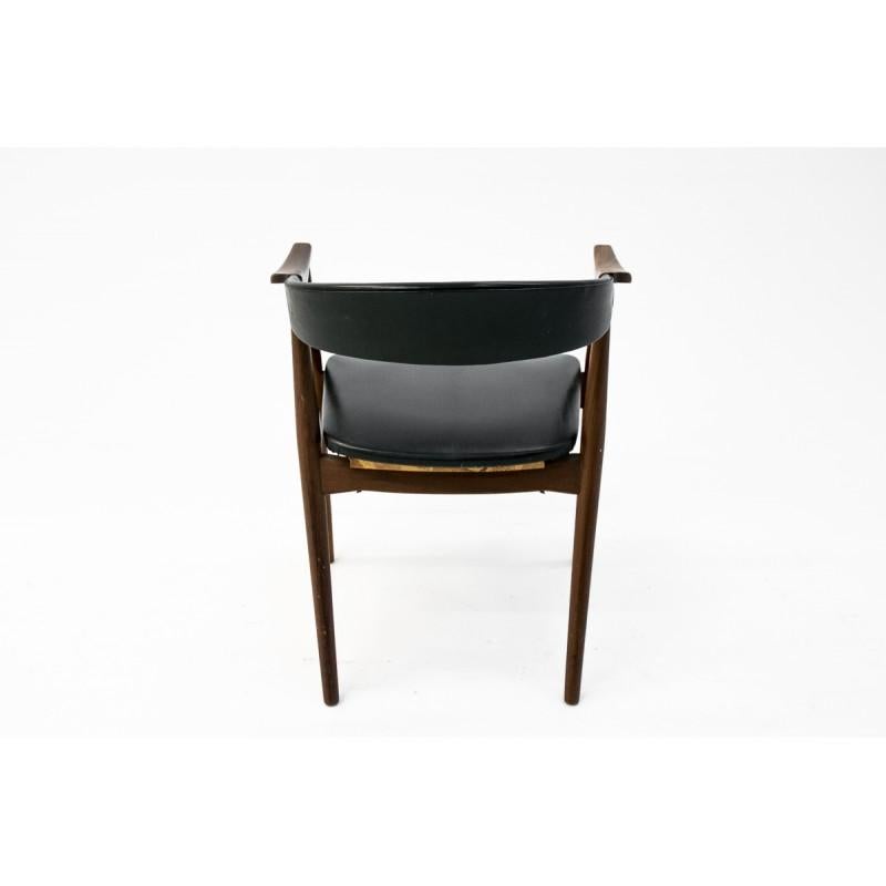 This faux leather (skai) armchair was designed in the 1960s in Denmark. It is made of rosewood, it is covered with original black faux leather upholstery. It is in very good condition. The wooden elements have been renovated.