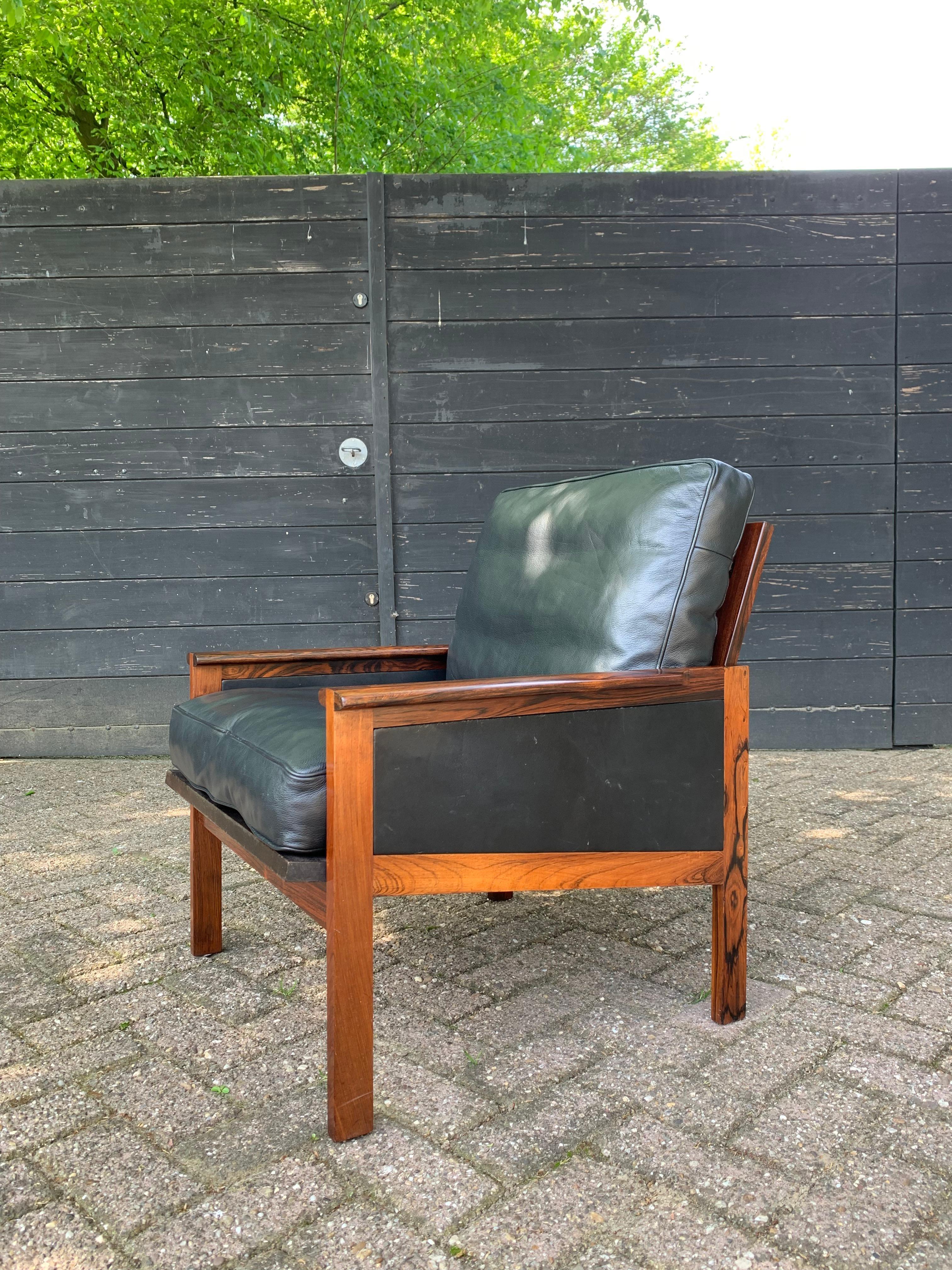 Arm chair model 4 from the Capella Series designed in 1958 by Danish designer Illum Wikkelsø executed in beautiful Rosewood with black leather loose cushions. Made by Danish manufacturer Niels Eilersen. 

Wikkelsø's background in cabinetry instilled