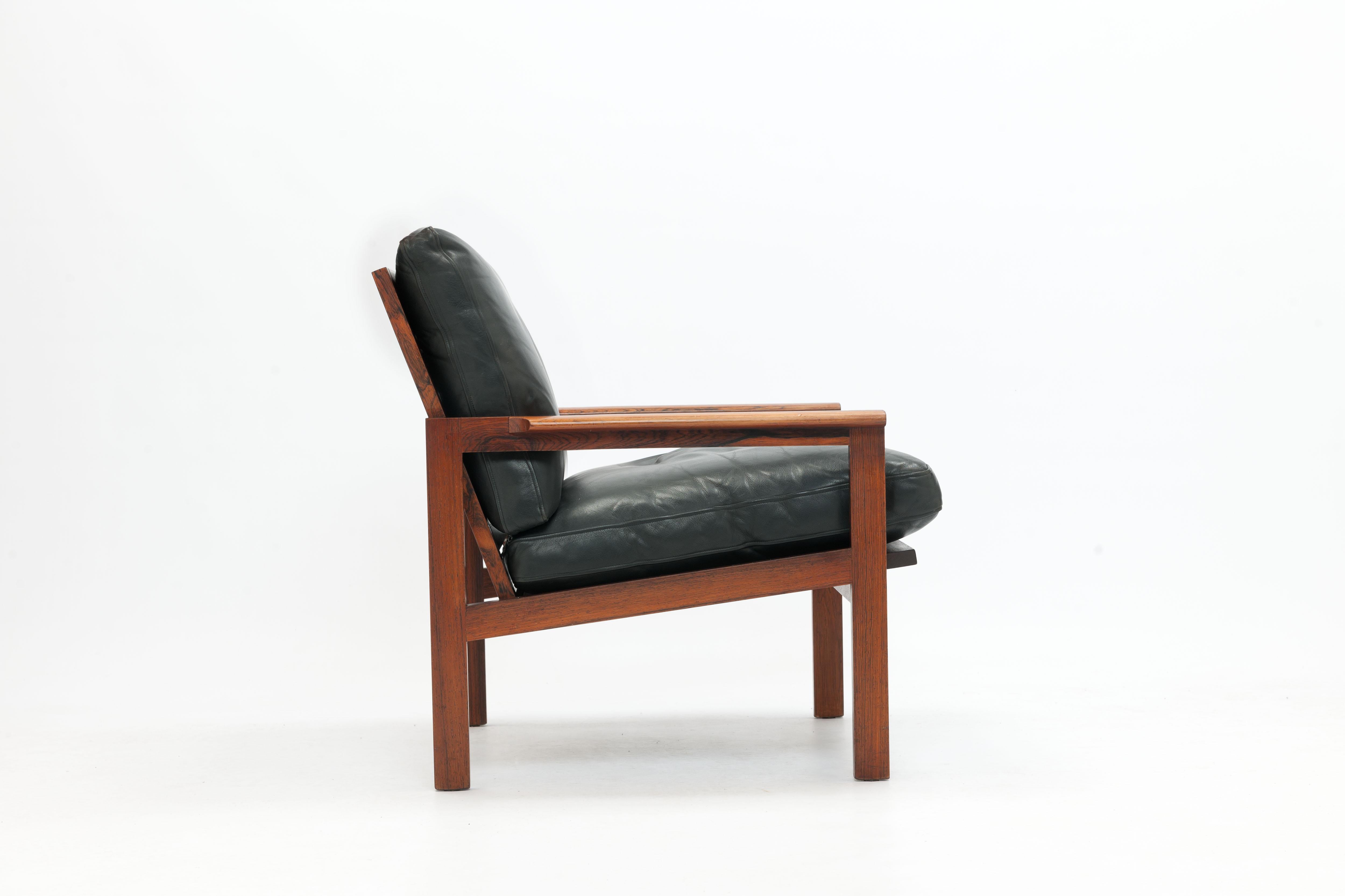 Arm chair model 4 from the Capella Series designed in 1958 by Illum Wikkelsø executed in beautiful Rosewood with black leather loose cushions. 
Made by Danish manufacturer Niels Eilersen marked to underside of seat.

Wikkelsø's background in