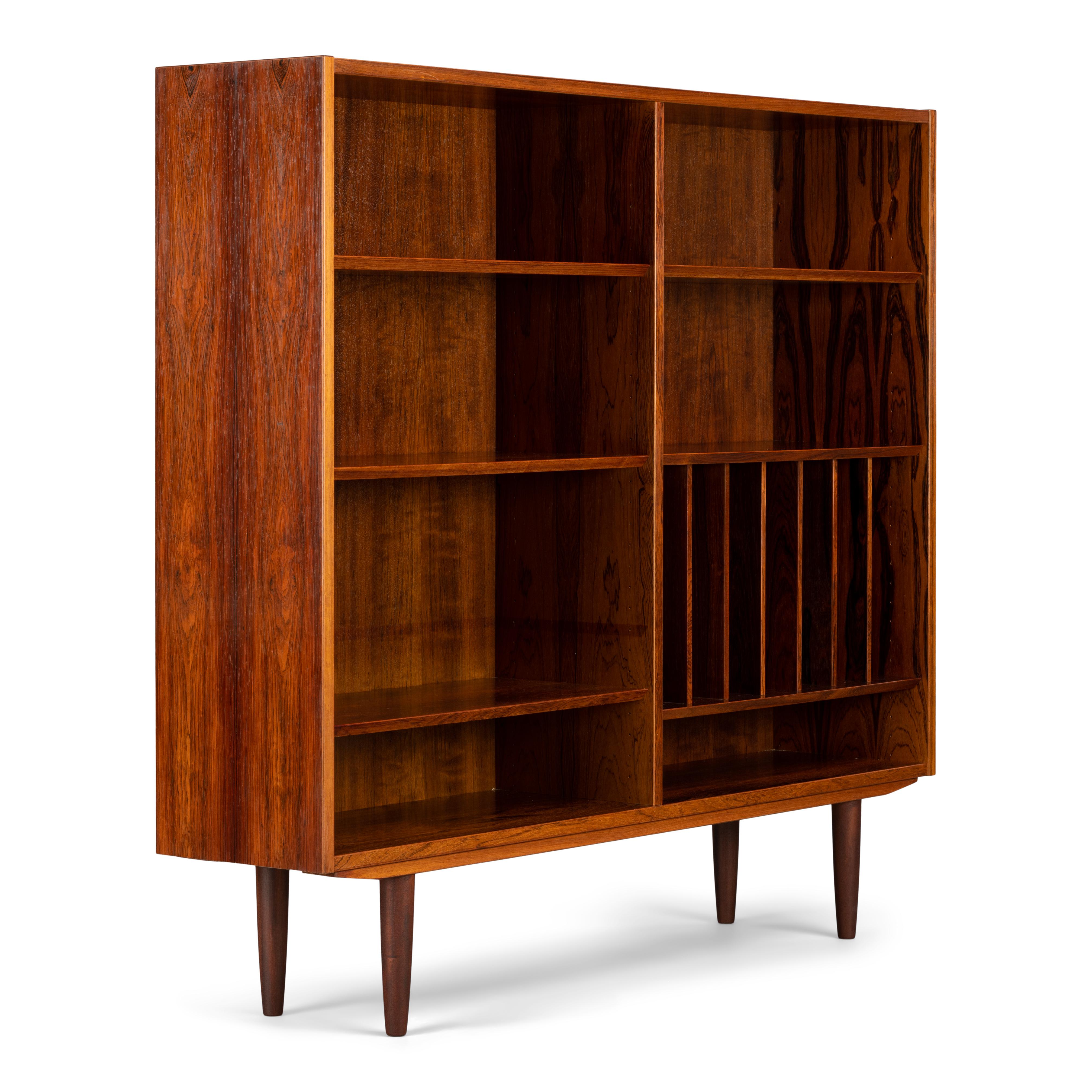 Danish rare tall bookcase in beautiful hardwood veneer. Designed by Carlo Jensen and made by Hundevad & Co. This bookcase is in very good vintage condition and has a total of 6 height-adjustable shelves divided across the two halves of the bookcase.