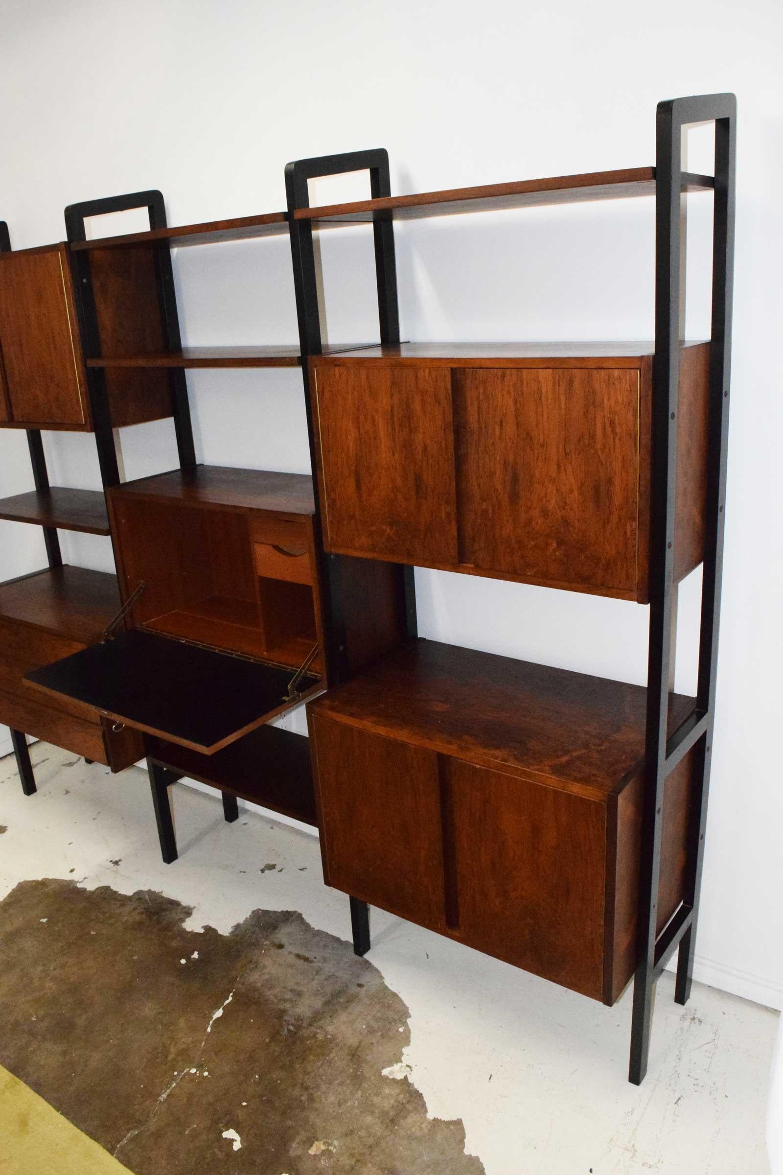 3 bay bookcase and storage unit in rosewood. Has cabinets and drawers as well as a drop door with key.