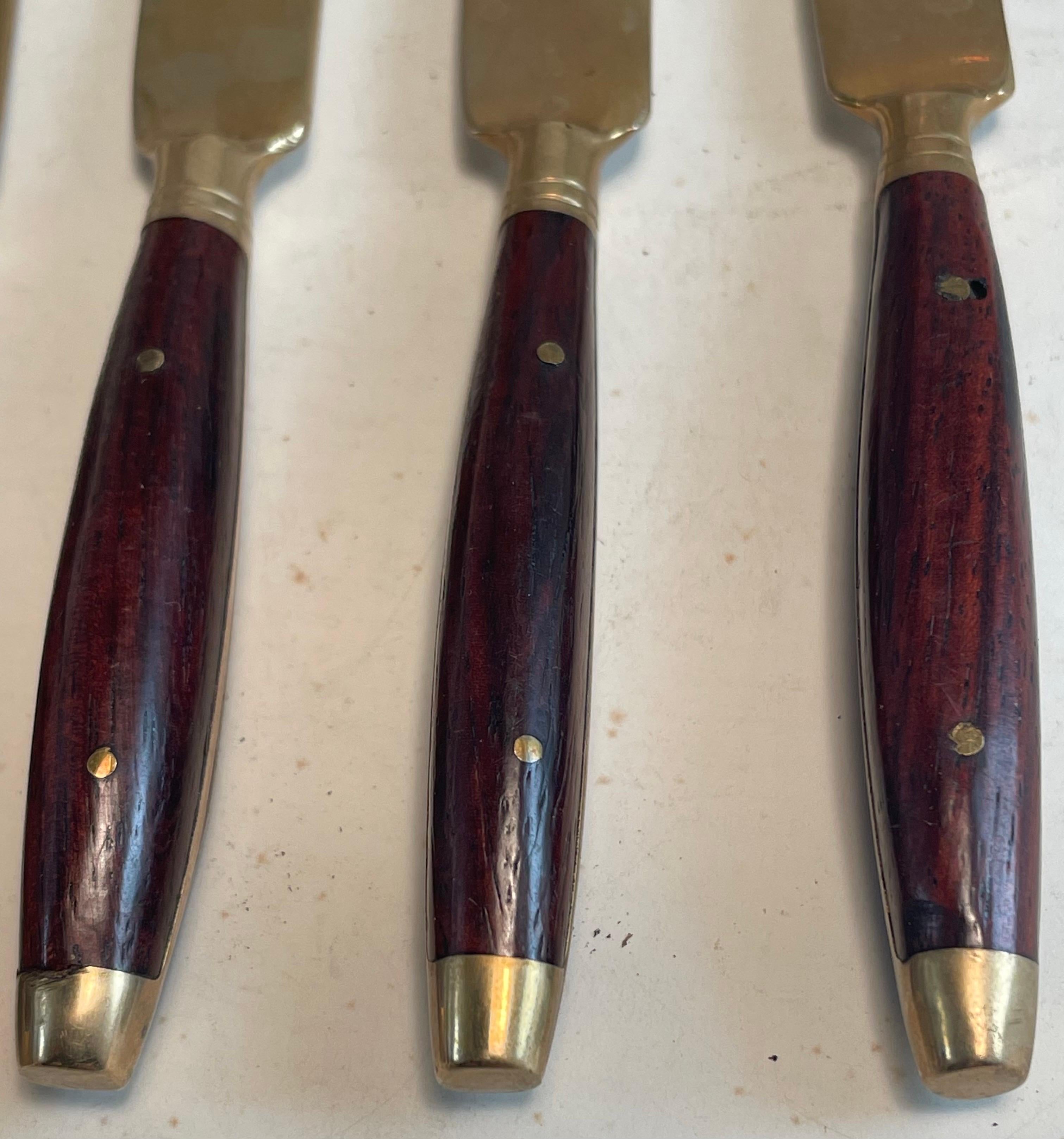 Dies ist ein sehr süßes Set von 4 einzelnen Butter- oder Dessertcrememessern aus Messing mit Palisanderholzgriffen. Sie haben eine schöne geschwungene Form, um die Klingen und sind in gutem Zustand mit dem Alter erwartet trüben und Oxidation auf das