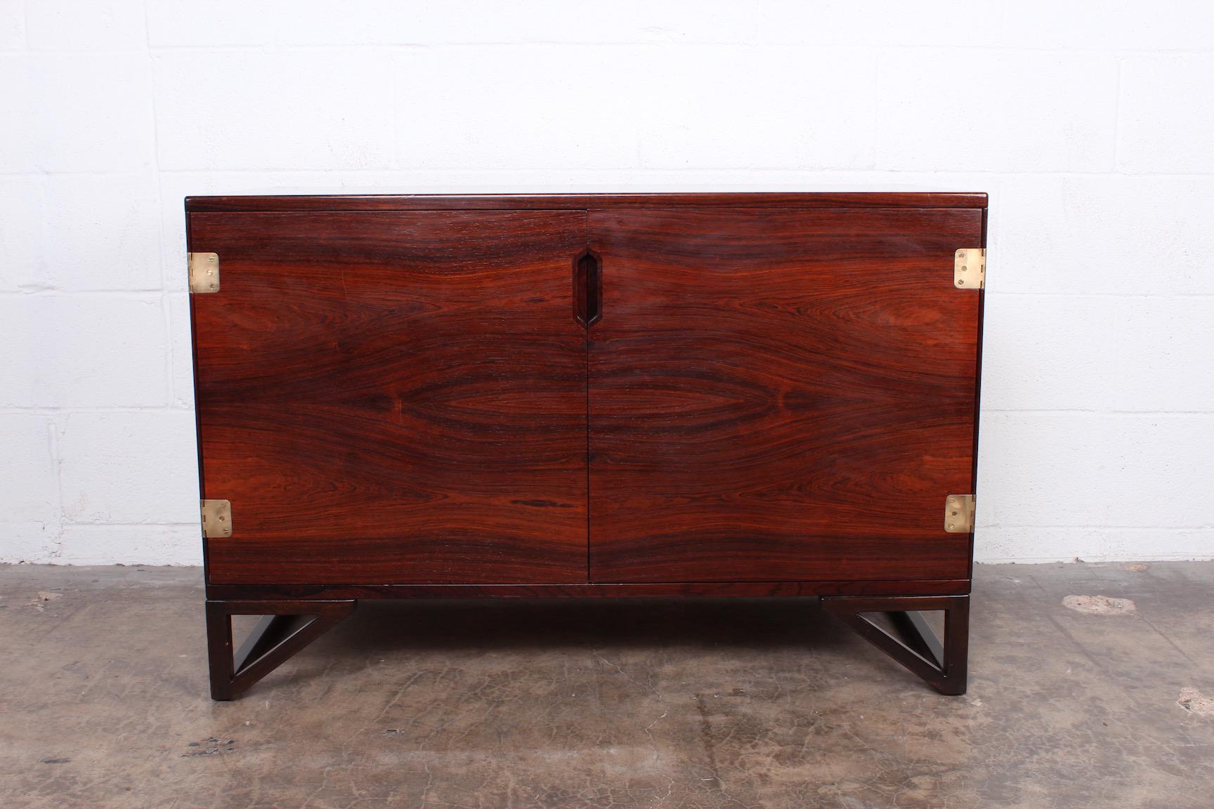 A rosewood cabinet with inset brass hinges and removable treys. Designed by Svend Langkilde.