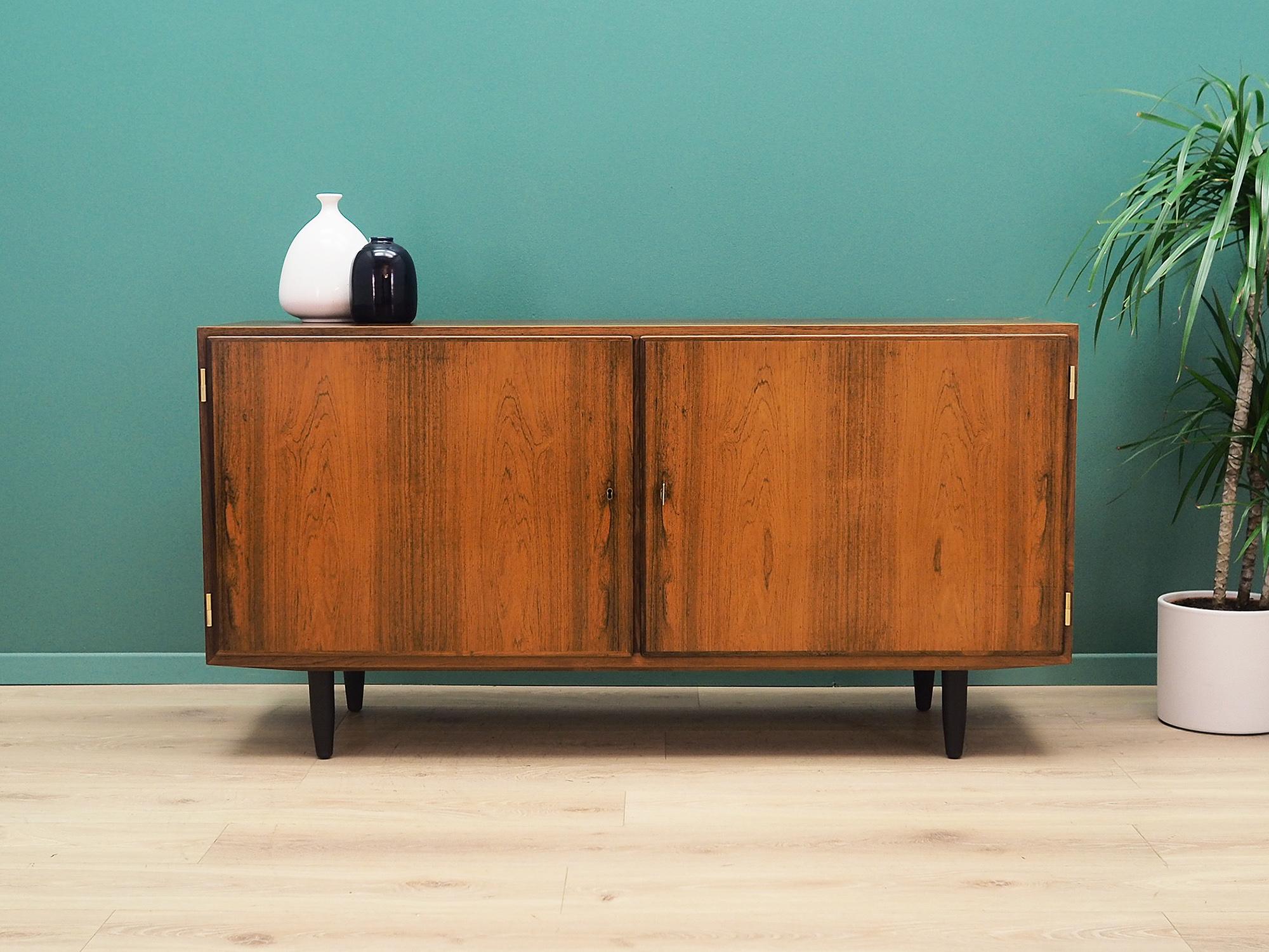Cabinet was made in the 1960s and was produced by the well-known Danish manufactory Hundevad. It was designed by a leading Danish designer Carlo Jensen.

The structure is covered with rosewood veneer. The legs are made of solid wood stained black.