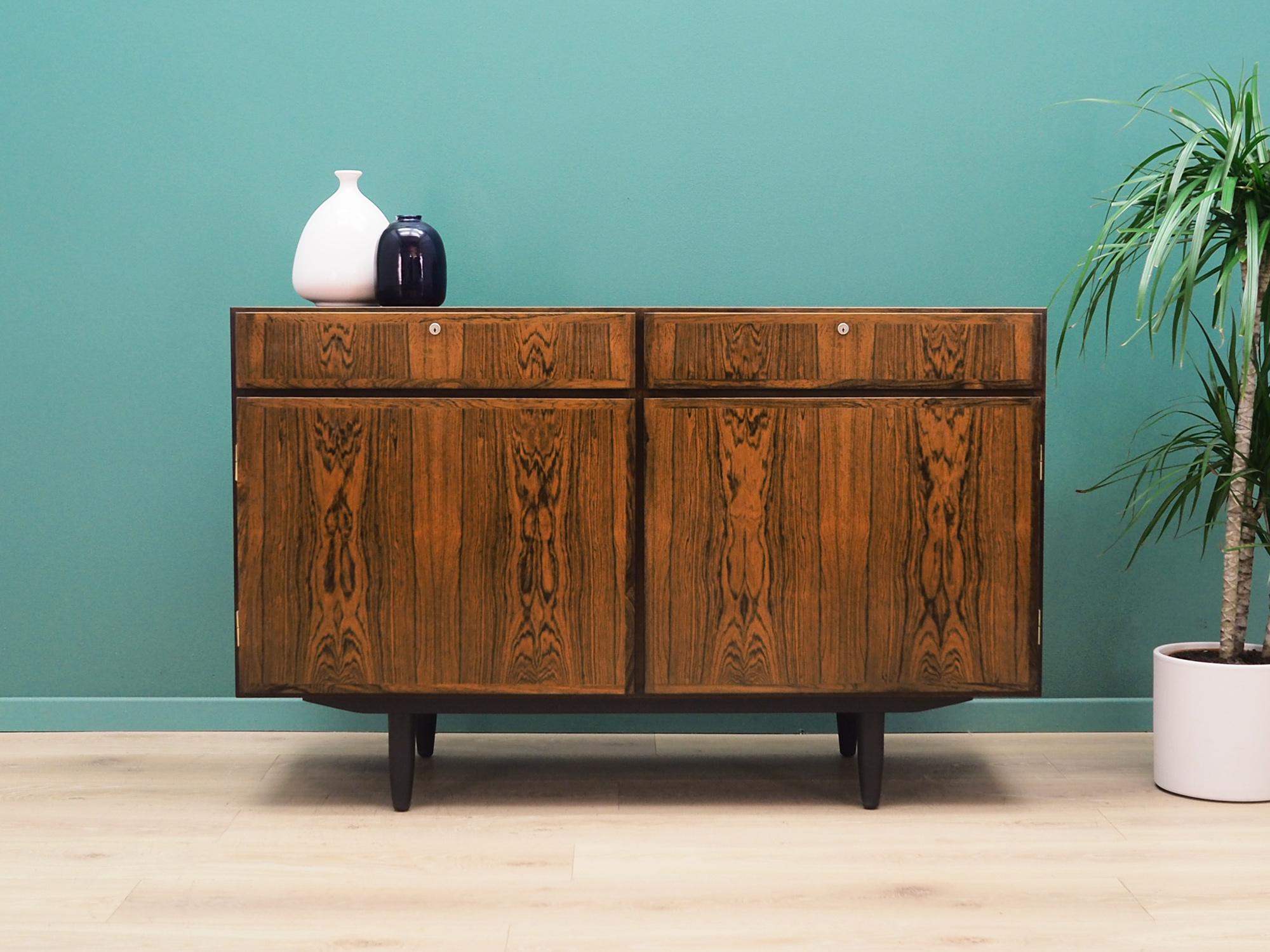 Cabinet was made in the 1960s and was produced by the well-known Danish manufactory Omann Jun.

The construction is covered with rosewood veneer. Legs made of solid wood stained black. The surface after refreshing. Inside the space has been filled