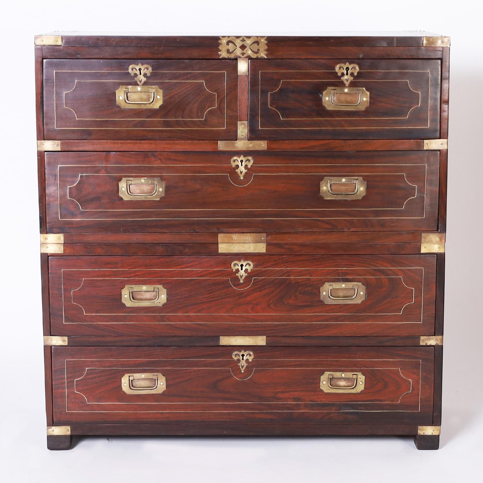 19th century Anglo Indian five drawer chest crafted with rosewood in classic form with a desirable slim profile, featuring brass hardware, geometric string inlays and floral escutcheons.