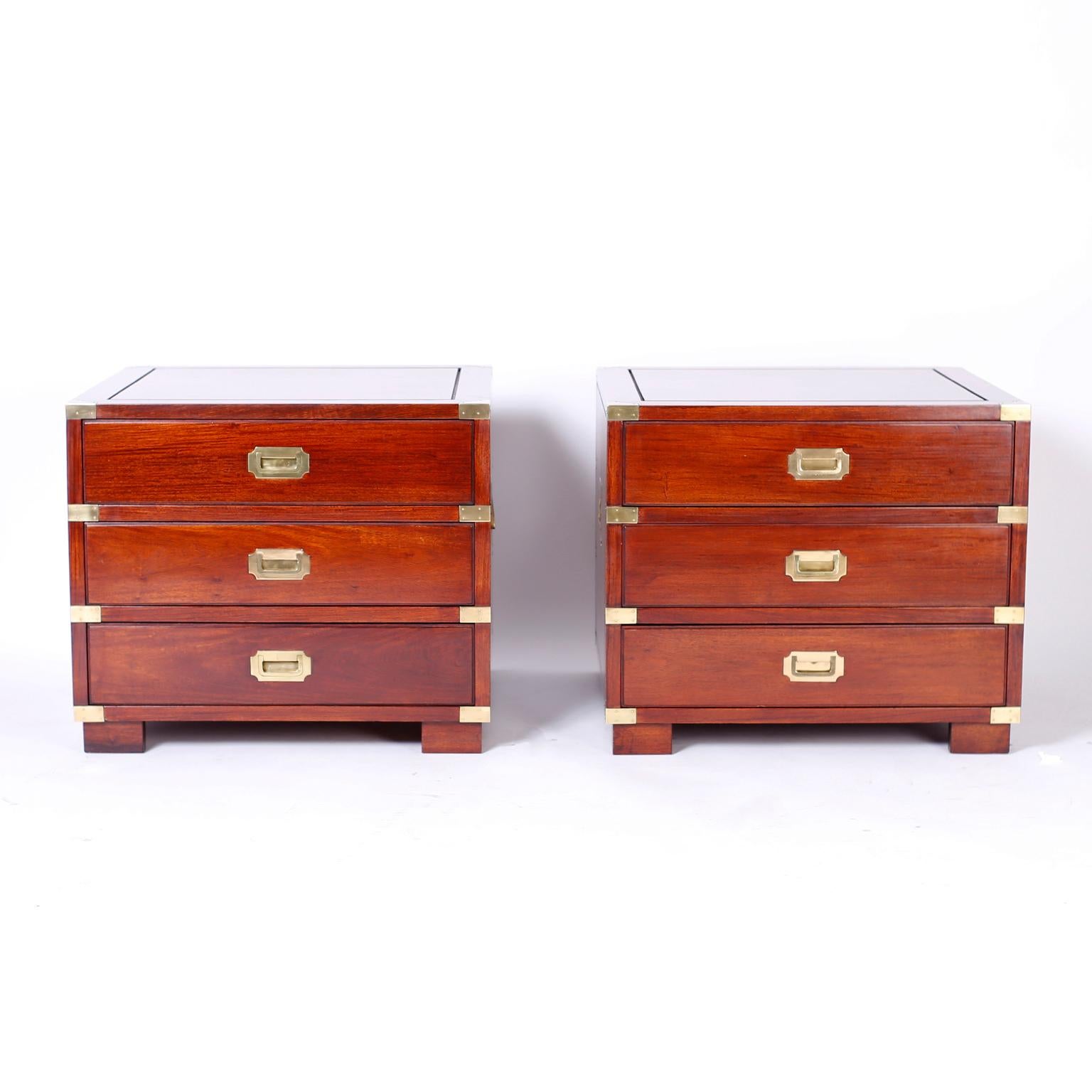 
Campaign Style Nightstands or Chests. Impressive campaign style three drawer stands with a bold large scale, crafted in rosewood with paneled tops and sides, campaign brass hardware, and block feet. Perfect marriage of tradition and modern.
