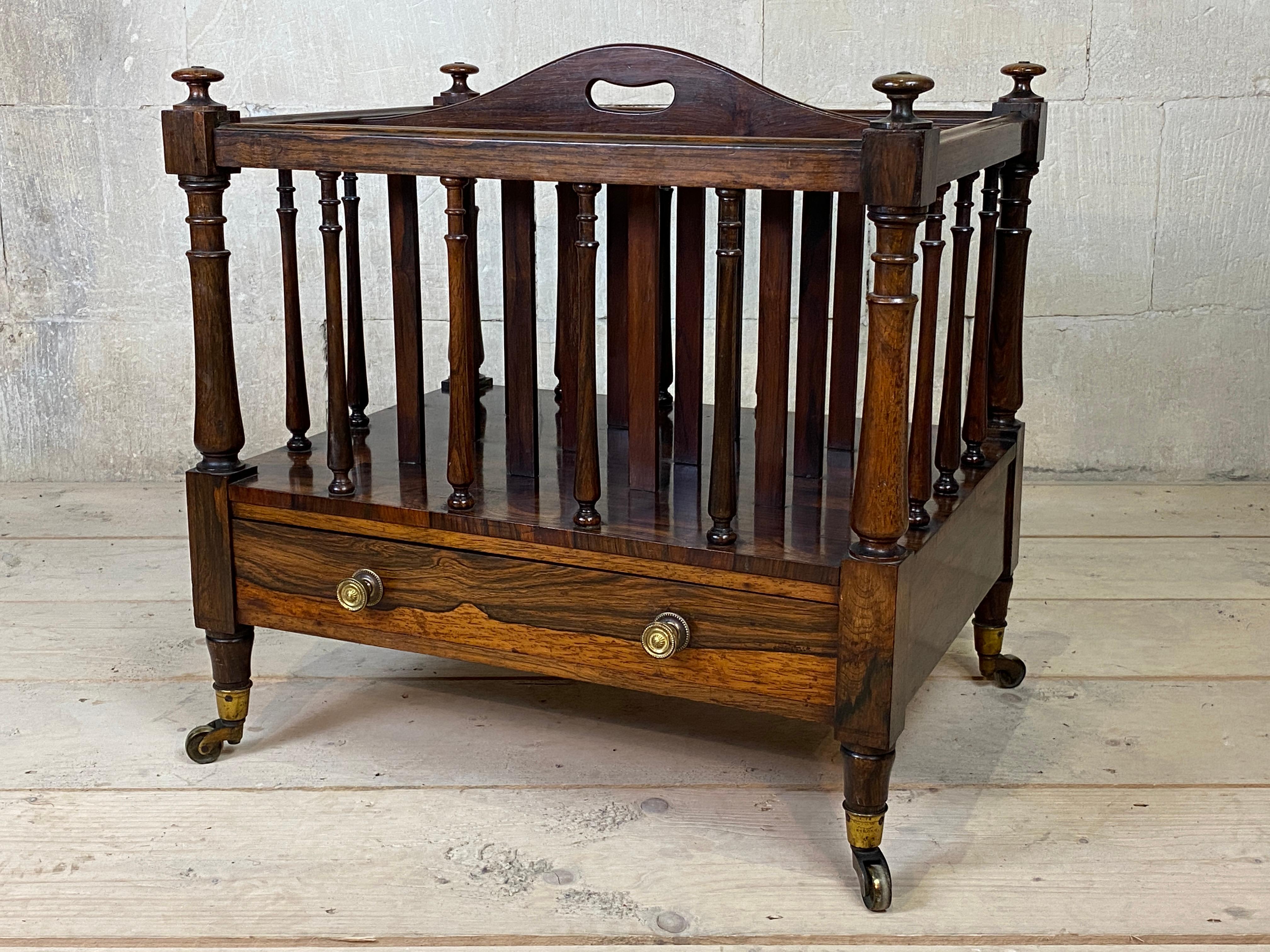 Victorian rosewood four division Canterbury by Holland & Sons, with central handle cut-out, molded top rails supported by turned corner columns and interspersed by turned spindles, the base fitted one single drawer (stamped), raised on turned legs