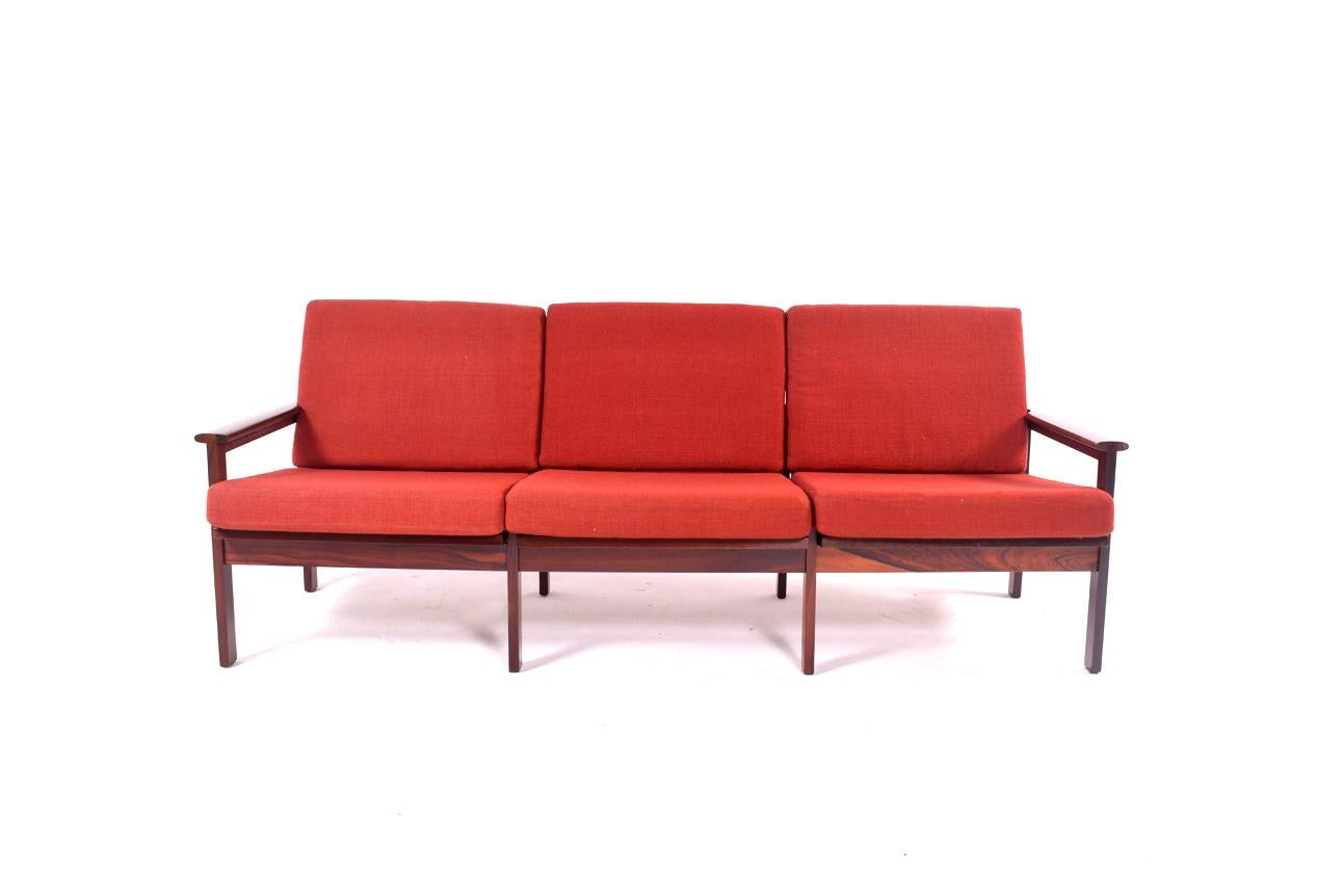 Danish three-seat sofa designed by Illum Wikkelso for Niels Eilersen. This iconic model “Capella” features a Minimalist rosewood frame with exposed joints in its armrests.