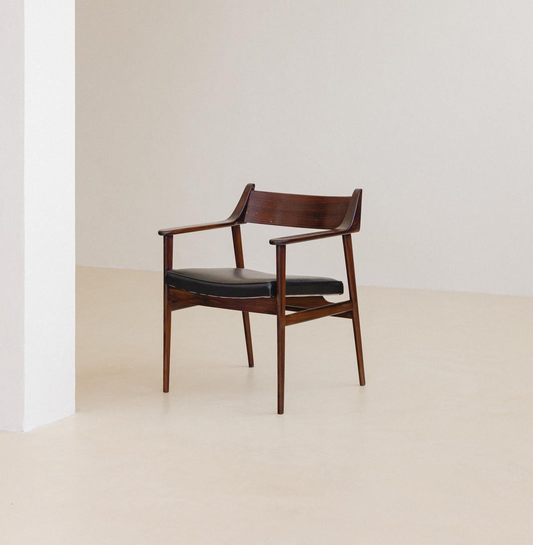 This pair of chairs with armrests made in solid rosewood and leather was produced by Cantù Móveis e Interiores Ltda. in the 1960s. This model was manufactured with seats in cane or leather, and it was part of a collection focused, at the same time,