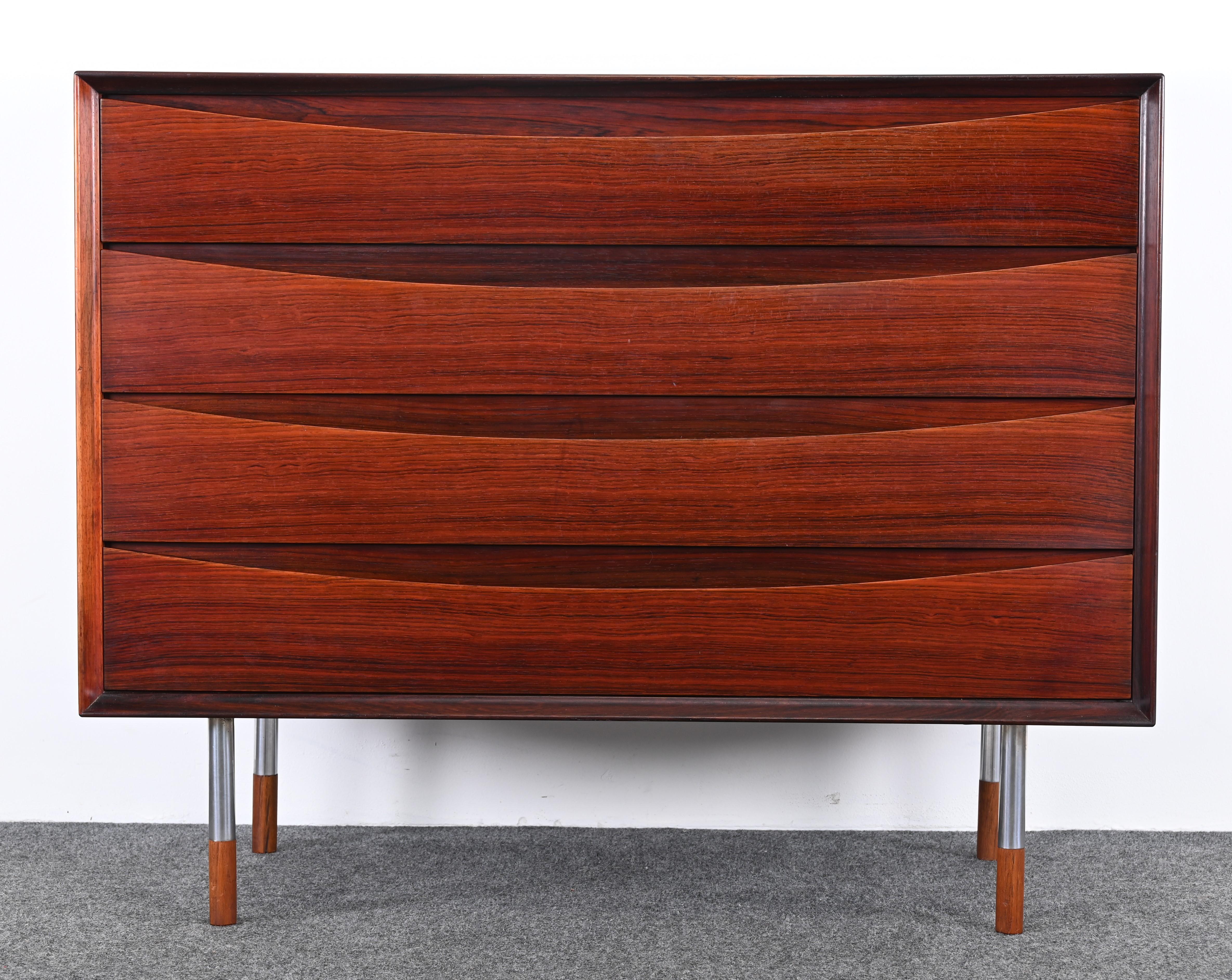 A gorgeous rosewood Chest of Drawers by Arne Vodder for Sibast, 1950s. This Scandinavian Modern cabinet seems to be rare as it has metal legs instead of wood and there are not many on the marketplace. The Danish rosewood chest would look great in