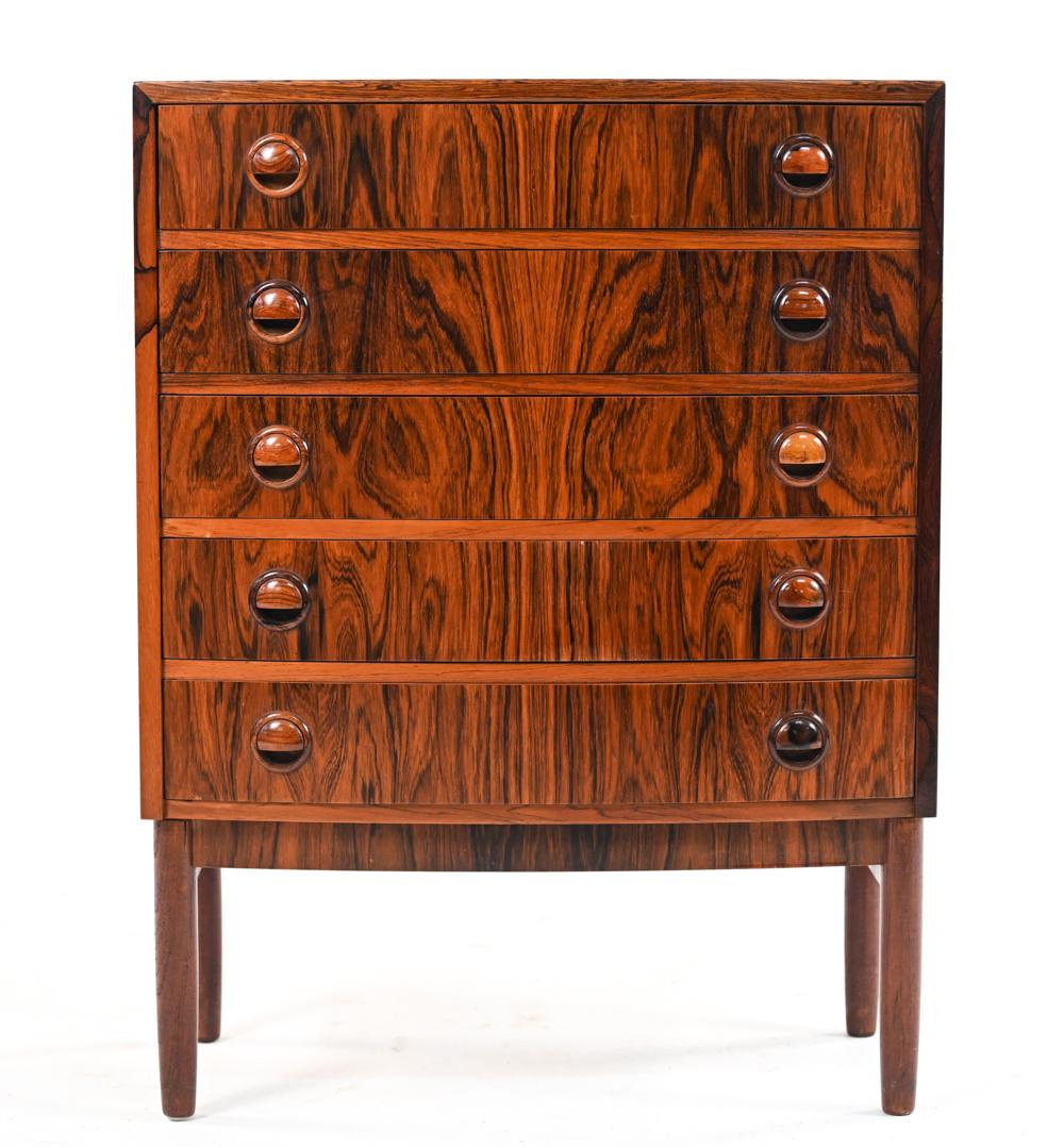 A gorgeous and playful small dresser in rosewood veneer, with subtle bow front, sculptural half-lid drawer pulls and dovetailed maple and pine drawers. Designed by Kai Kristiansen, c. 1950's.