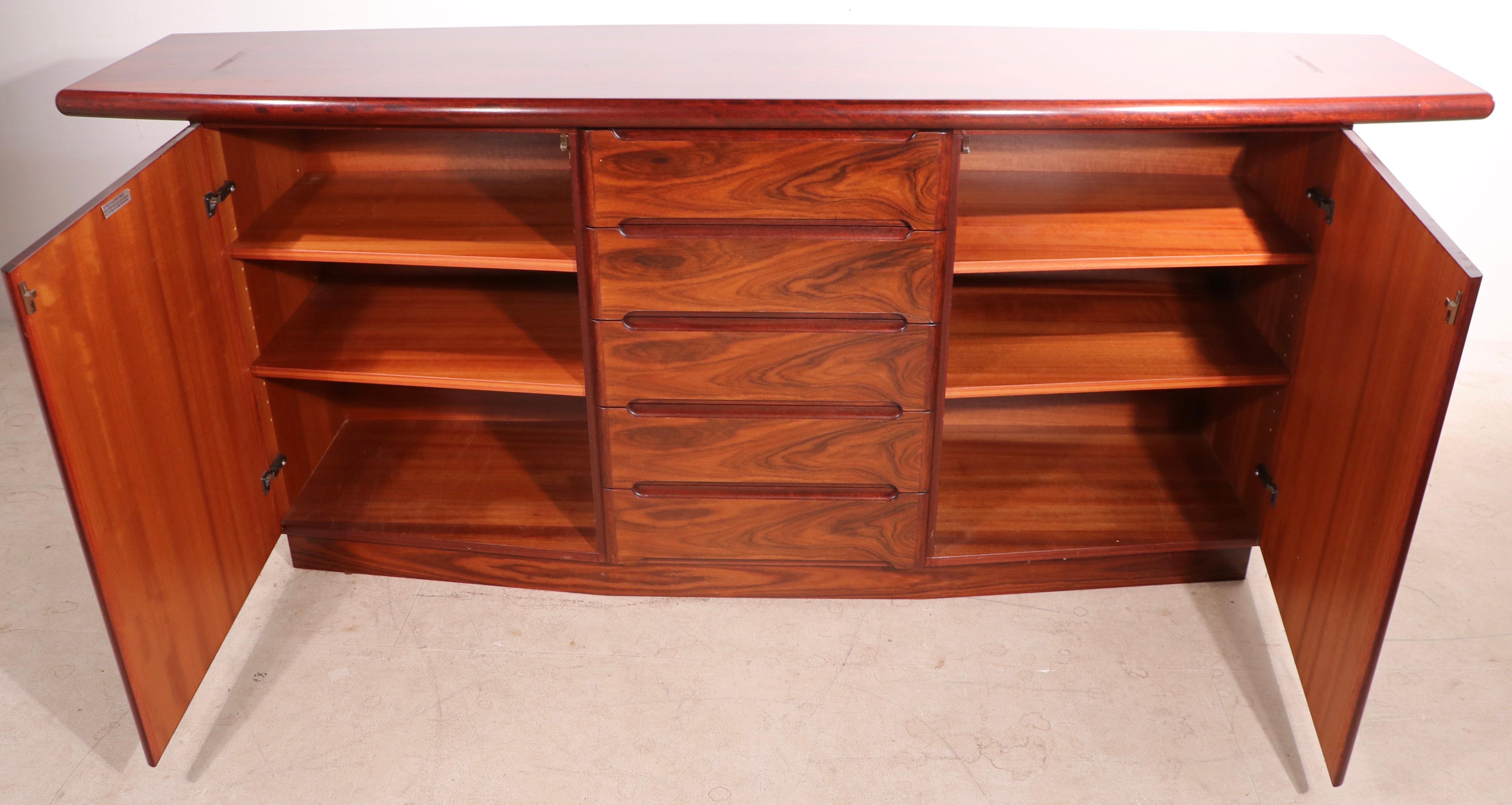 Impressive rosewood china  cabinet made in Denmark by Skovby Mobelfabrik circa 1960’s. The cabinet consists of a large base ( 78.5 W x 19 D x 32 H inches ), which can be used separately, and the top section ( 39.5 in.  ). The base features two doors