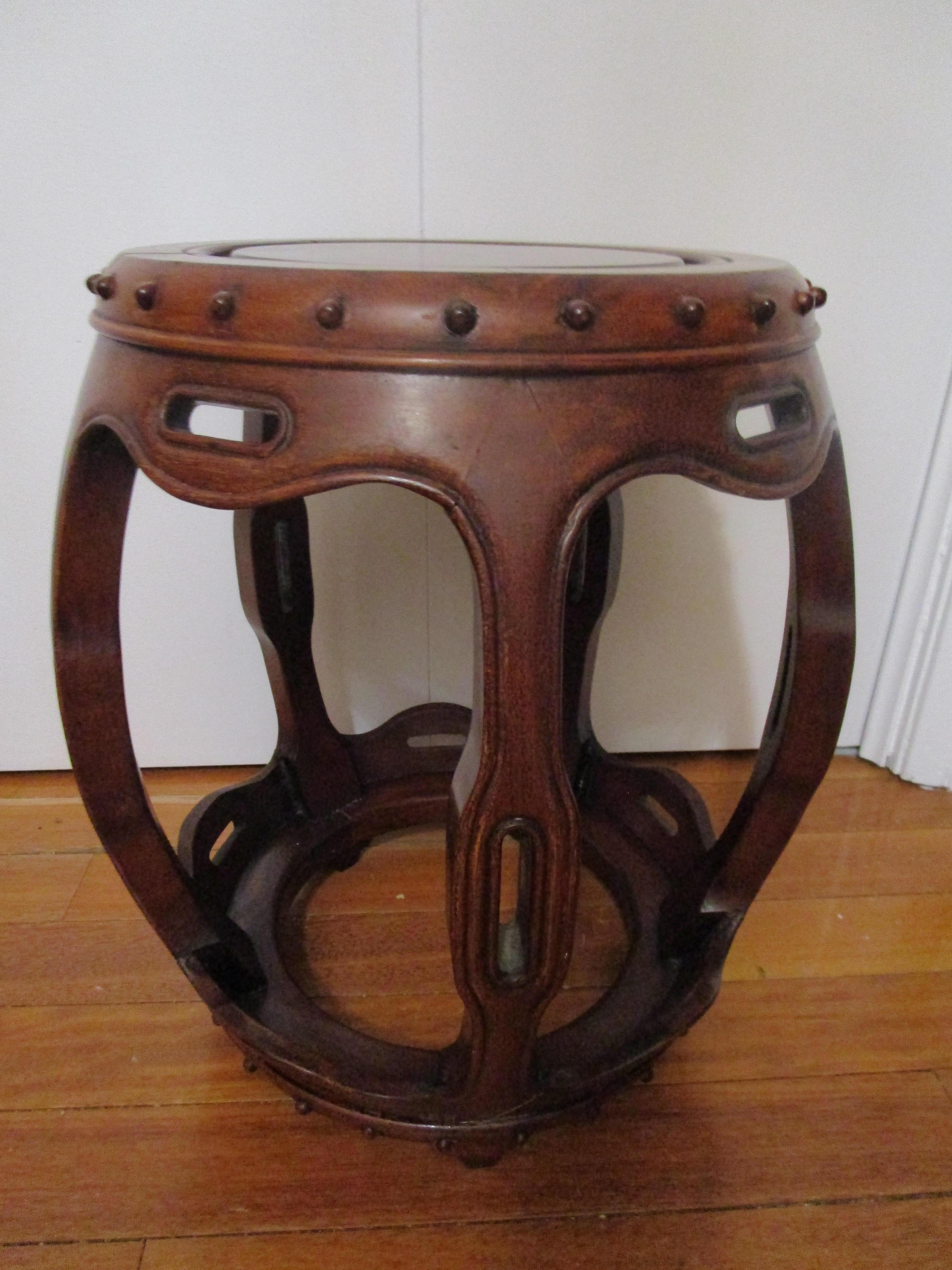 This solo rosewood garden seat has the most beautiful patina with red undertones. This Chinese rosewood barrel shaped garden seat is in the Ming style but  mid-century production. It is sturdy and beautiful with a rich patina.
There is a raised
