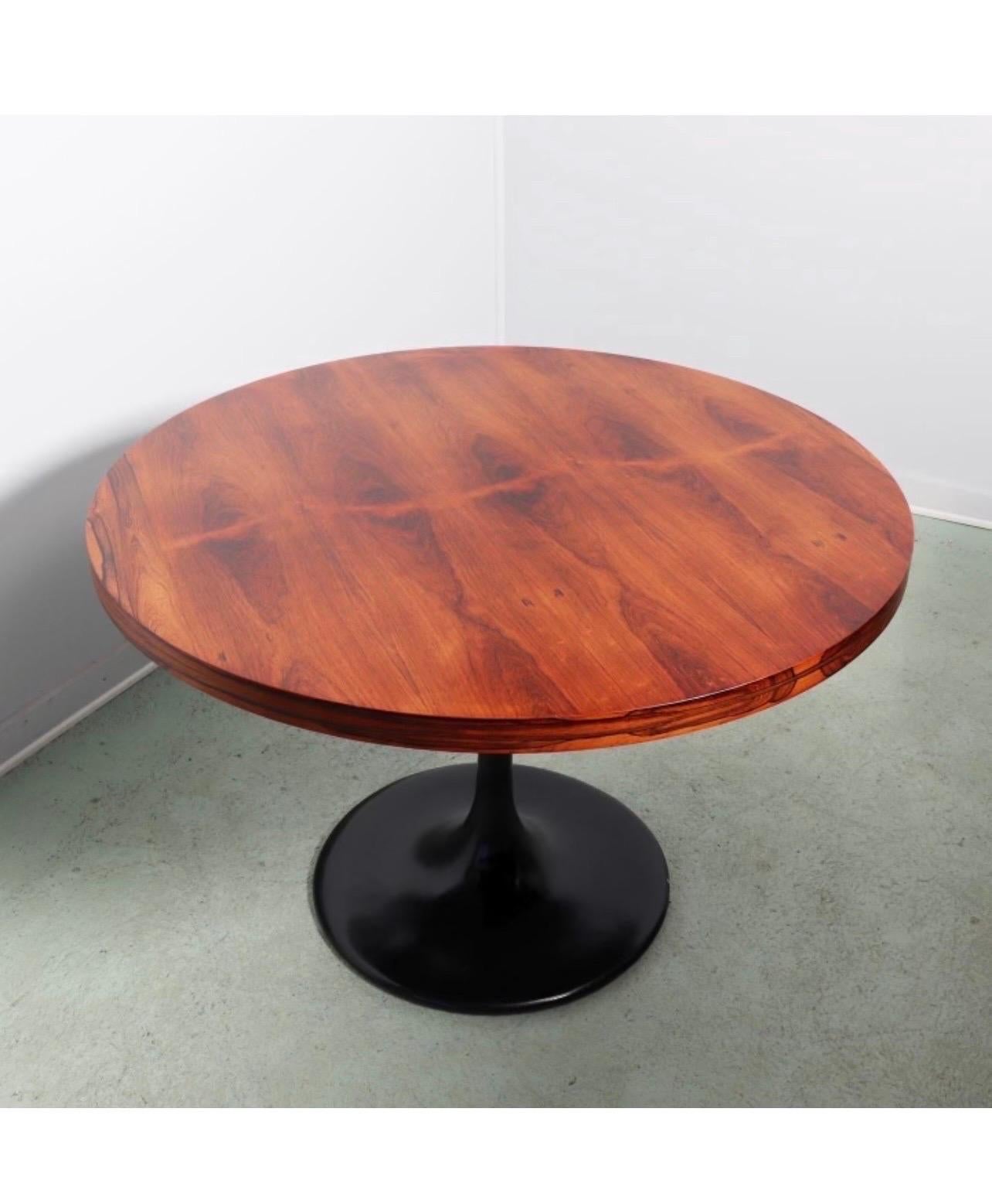 Elegant rosewood round dining table by Milo Baughman that is supported by a black tulip base for enhanced leg room and overall style. This sleek round rosewood wonder can be used as a dining table or foyer table. The 30