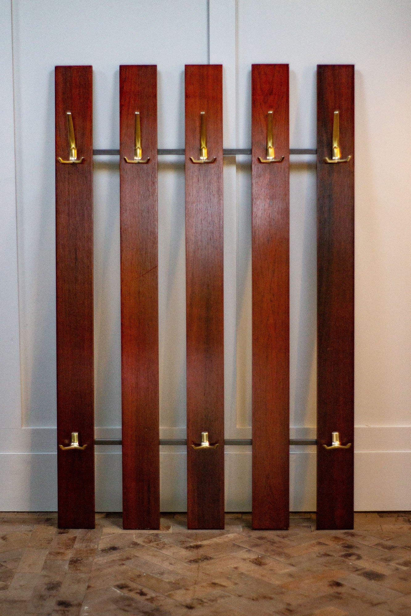 Danish coat rail made of rosewood with beautifully shaped metal hoods and a metal back frame. 

Measures: Height - 125cm

Width - 81cm

Depth - 13cm.