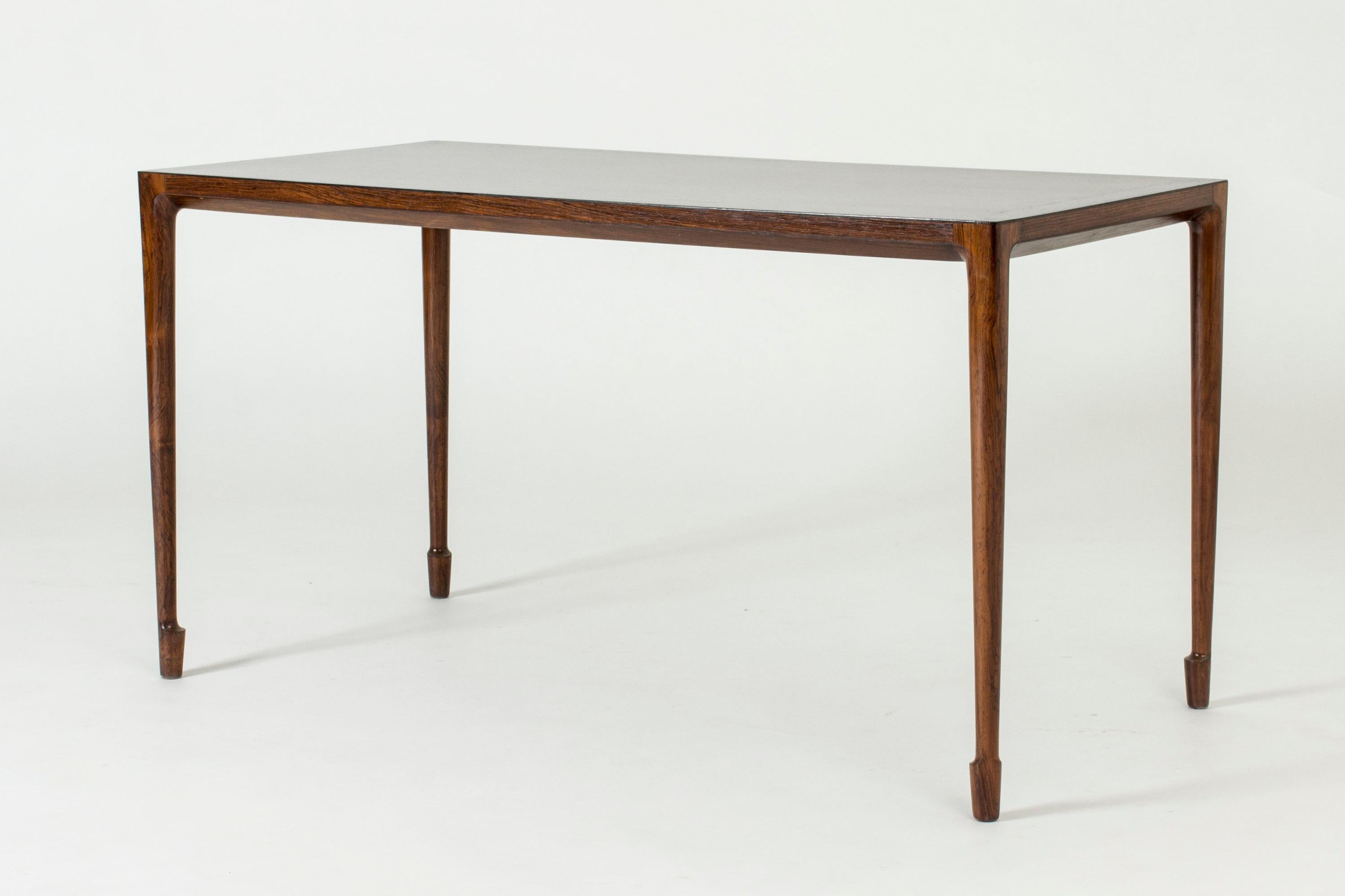 Elegant rosewood coffee table by Bernt Petersen, with a smooth top. Amazing slender design with beautifully sculpted feet.