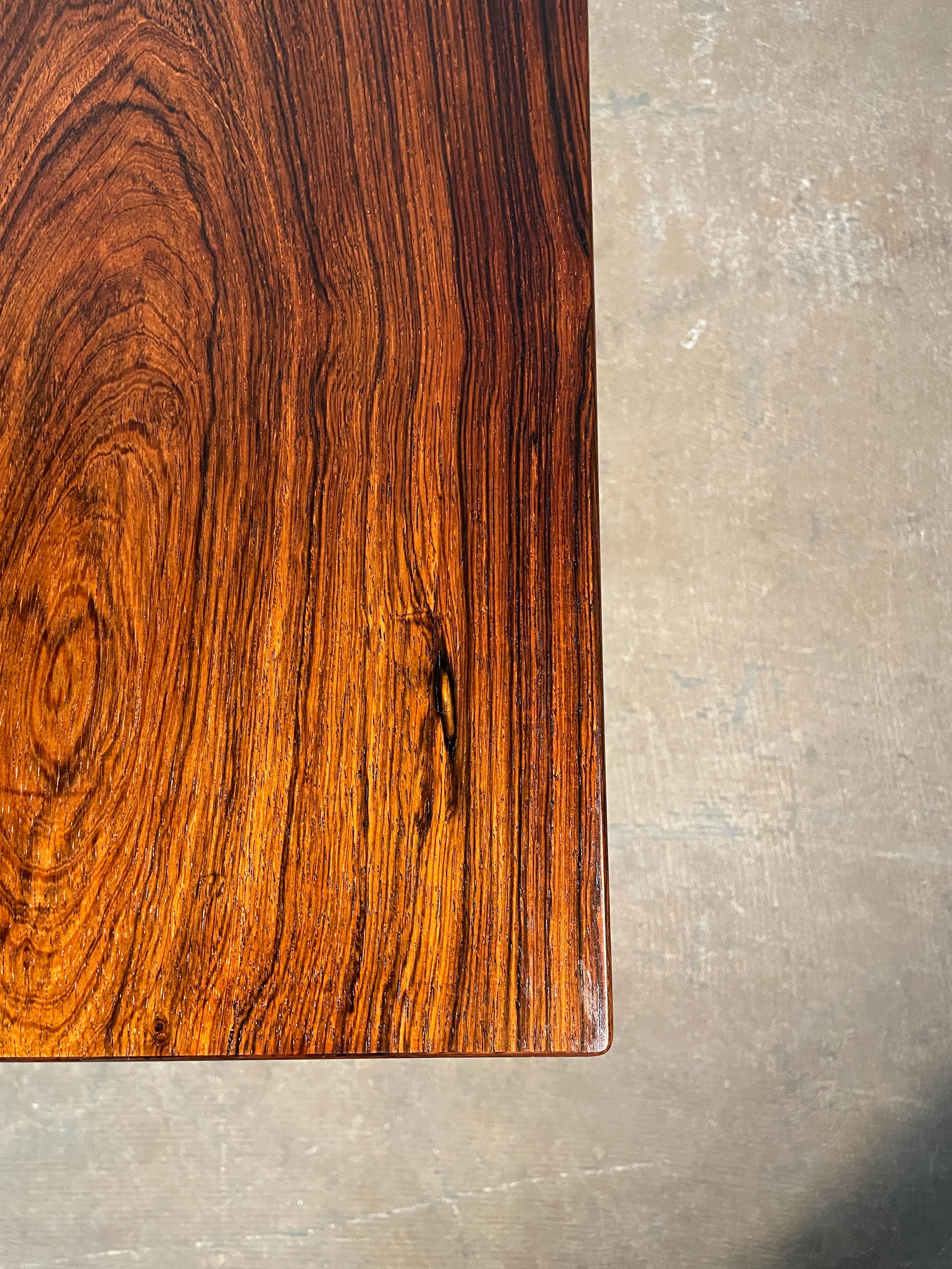 Cette table basse rare et délicieusement bien faite, modèle U55, a été conçue par Helge Vestergaard Jensen et fabriquée par l'ébéniste Peder Pedersen dans les années 1950. L'aspect le plus frappant de cette table basse est le grain de bois de