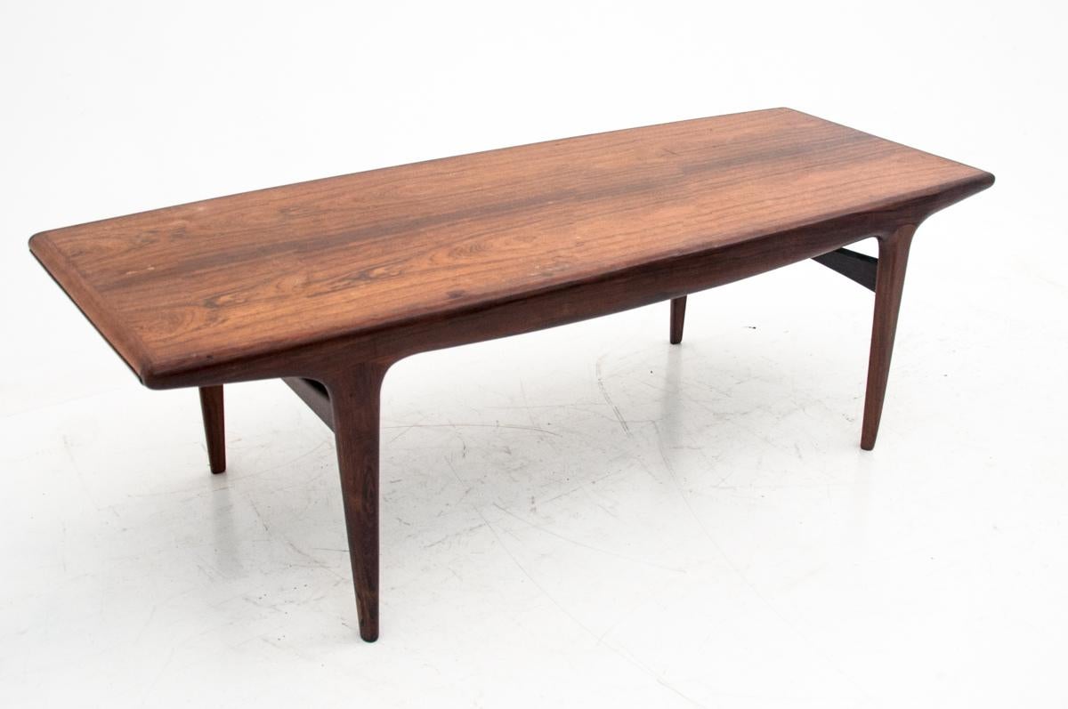 Rosewood coffee table in the form of a bench comes from Denmark from the 1960s. Designed by Johannes Andersen. On the sides, extendable shelves, one wooden one made of metal protecting the table from damage from hot dishes. Originally preserved in