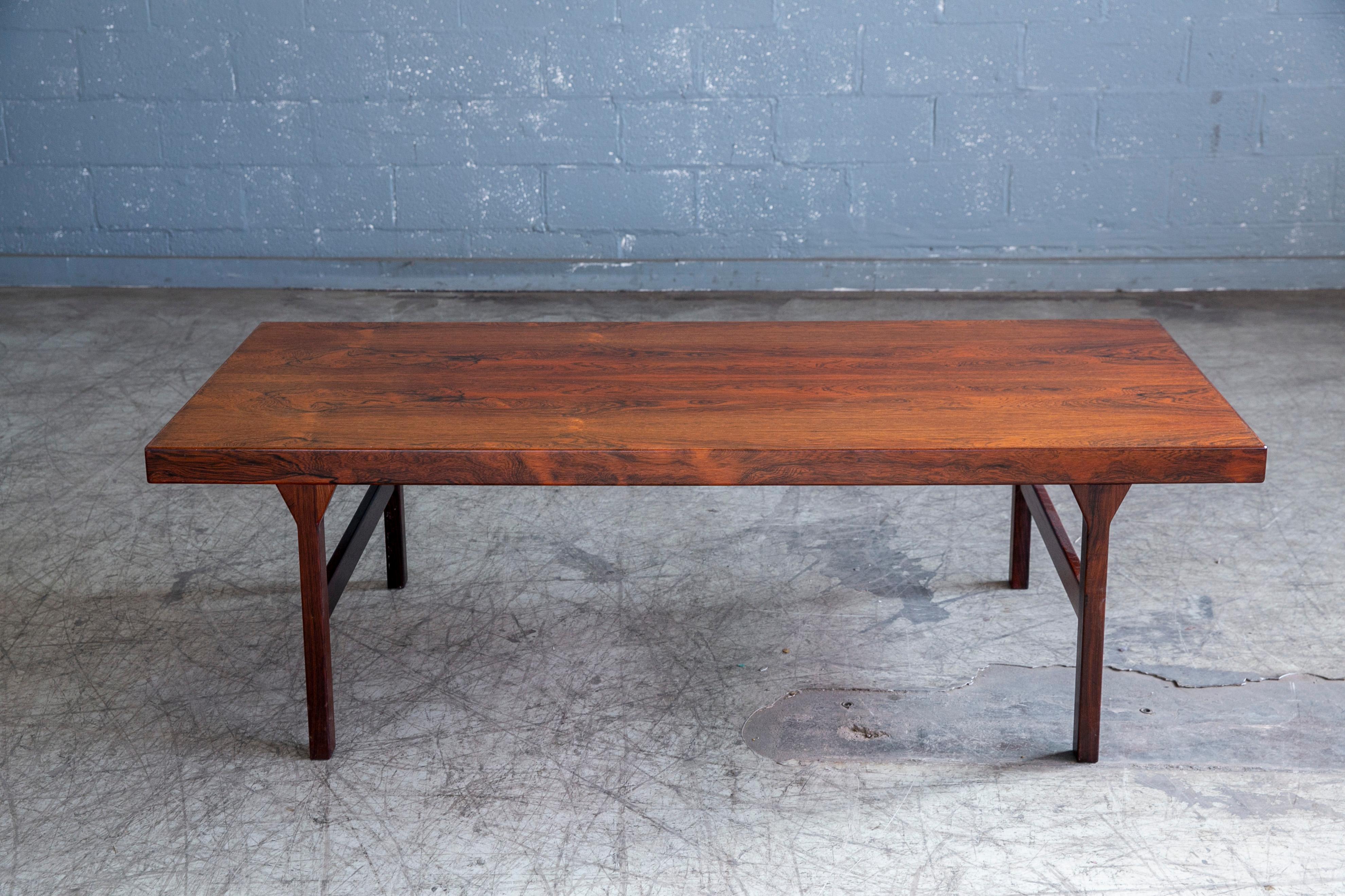 Beautiful rosewood coffee table by Johannes Andersden for CFC Silkeborg made in the 1960's. Andersens coffee tables epitomizes minimalist elegance with its sharp lines. The pull-out tray provides for an elegant space to put a bottle of wine or pot