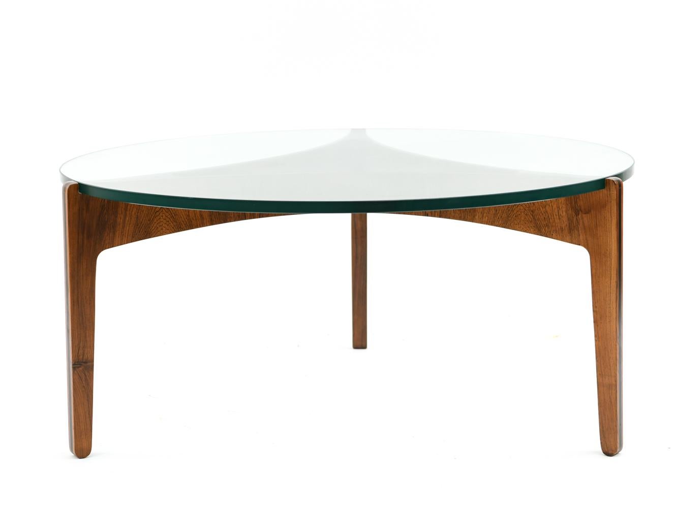 This gorgeous Danish midcentury coffee table was designed by Sven Ellekaer for Christian Linneberg, circa 1961. Featuring a sculptural rosewood base with ebony trim and a circular glass top.