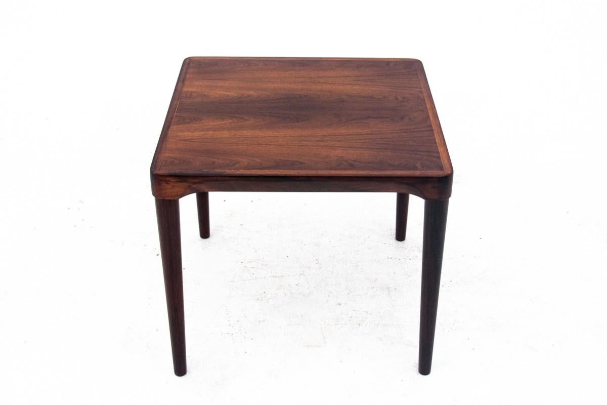 Rosewood coffee table, Danish design, 1960s.

A small, square coffee table that fits perfectly even in small rooms. The table's carcass is profiled and slightly widens where it joins the legs. The legs are tinted black. Timeless, minimalist