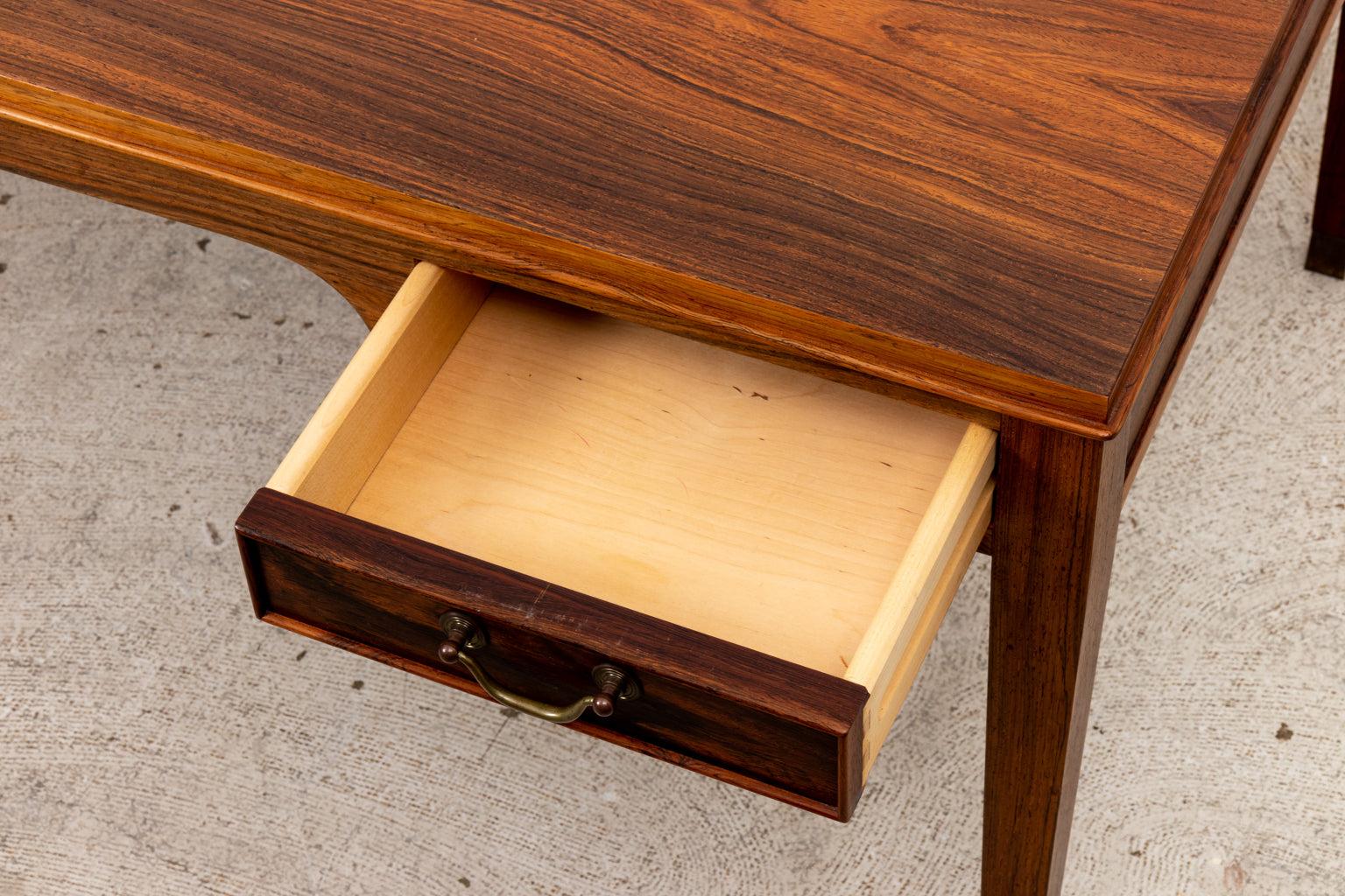 Rosewood coffee table featuring four small drawers (2 on each side), with brass capped feet and bail handles. Made in 1970s in Denmark. Please note wear consistent with age.
 