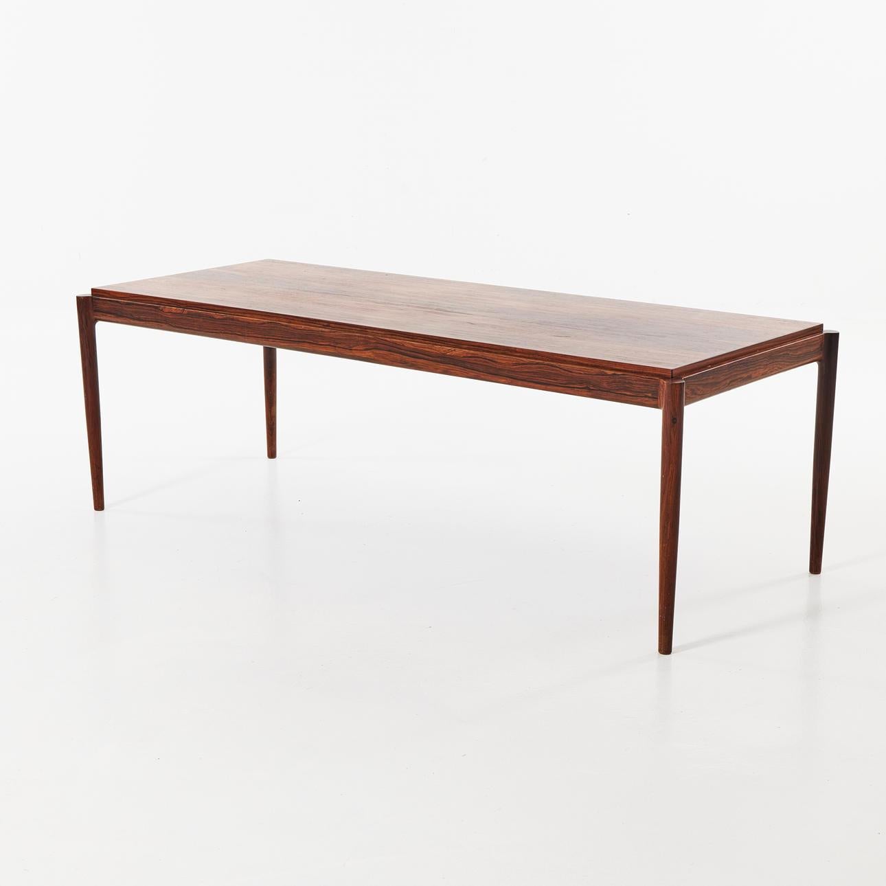 Elegant living room table by the great Danish designer Ib Kofod Larsen. Its legs outside the structure and its slightly raised top give it its refinement and originality and the rosewood, depth and warmth. This table is of high manufacturing quality