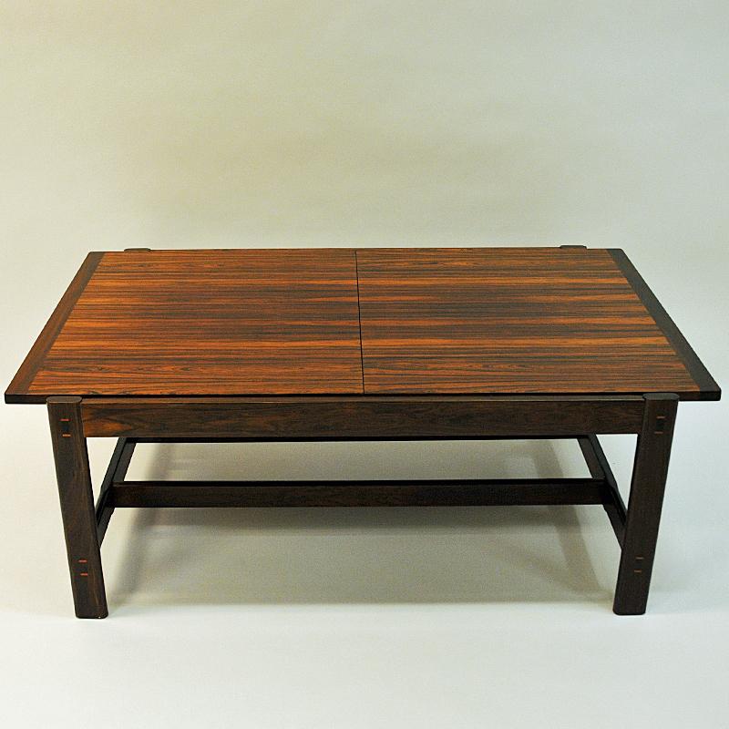 Magnificent and adjustable rosewood table for the livingroom. Designed by Torbjørn Afdal for Bruksbo 1962 and produced by Haug Snekkeri AS in the 1960s Norway. This smart table Sari has a black middle melamin plate to lenghten the table - or if