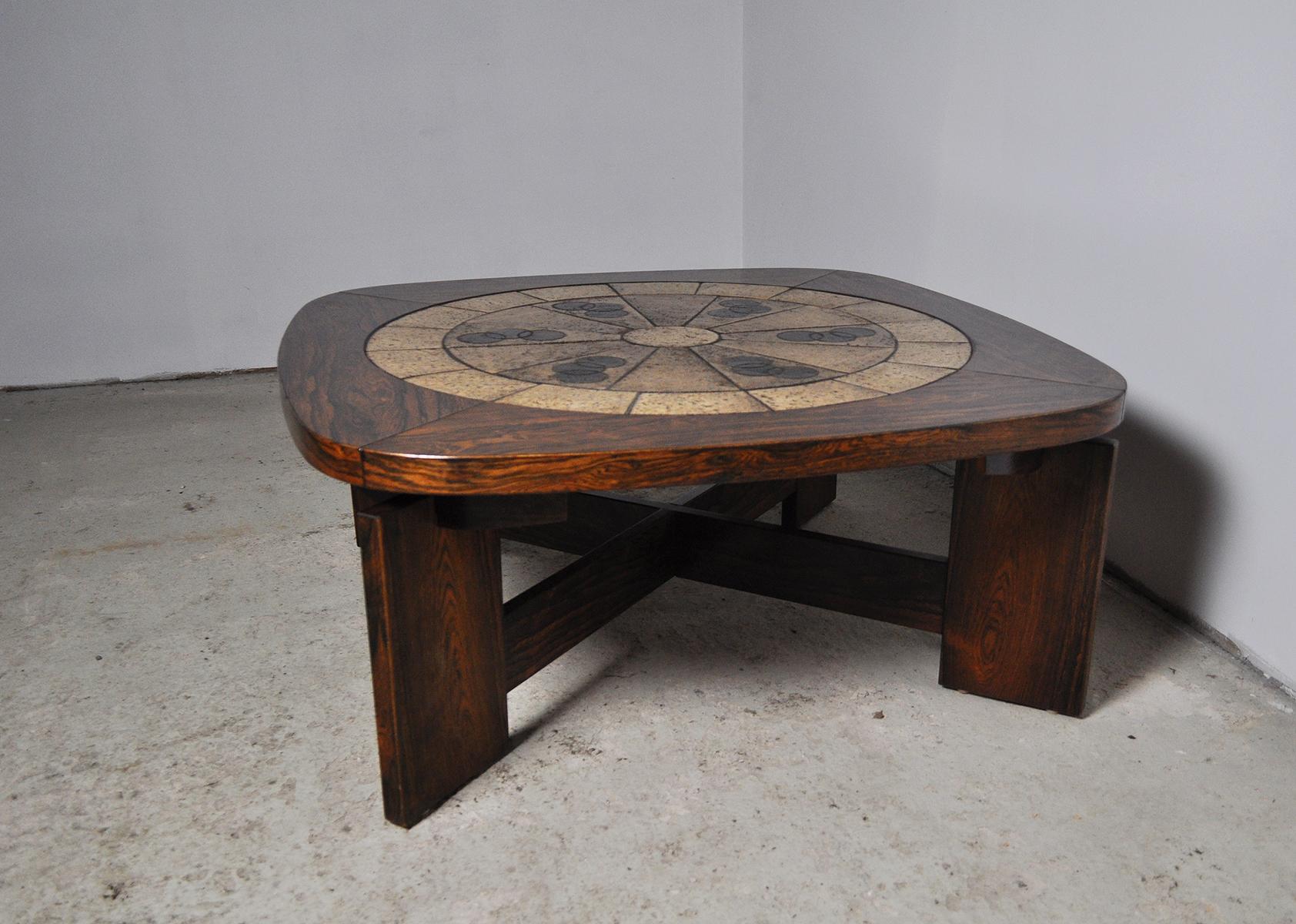 Rosewood veneer coffee table with ceramic tiles made in the 1970s.The table has jointed wooden legs supported by an X-base. 
Good vintage condition, signs of wear consistent with age and use.

Dimensions: 
Width 134.5 x 134.5 cm and 113.5 x