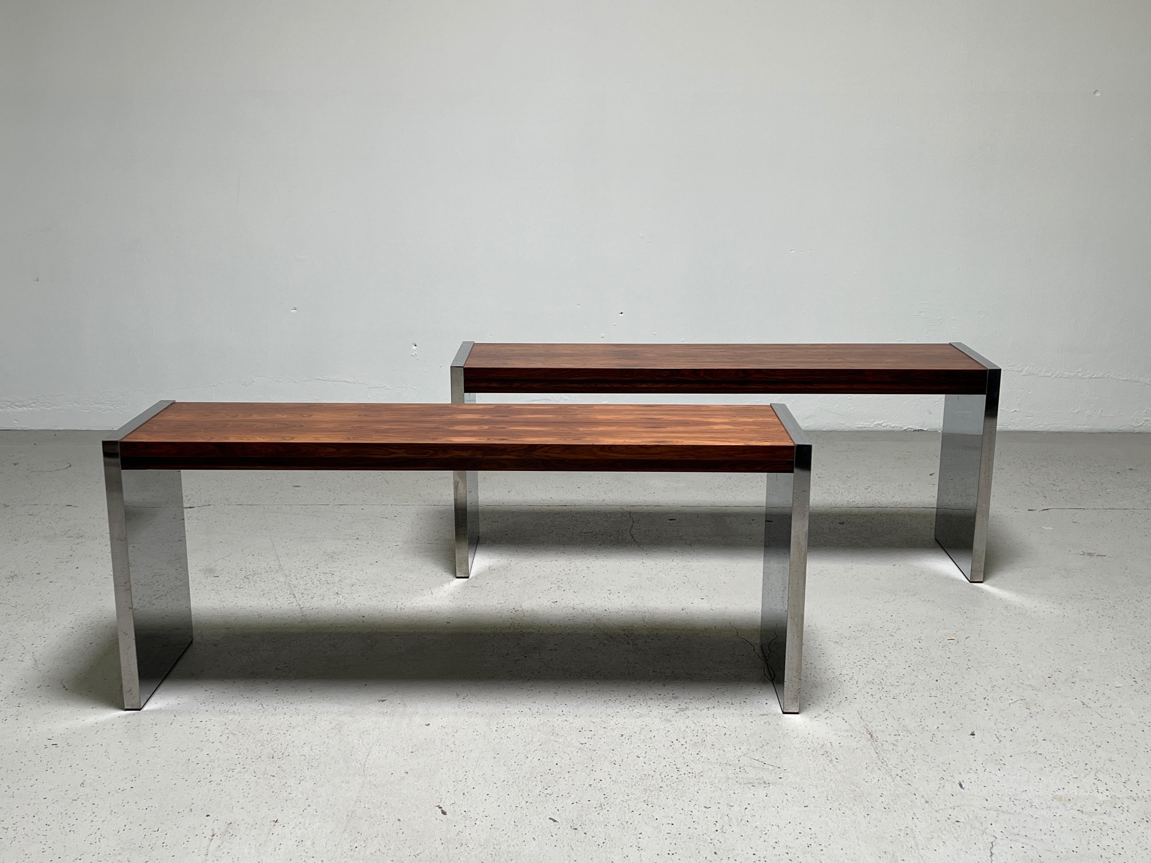 A pair of rosewood console tables with chrome sides. Designed by Roger Sprunger for Dunbar.