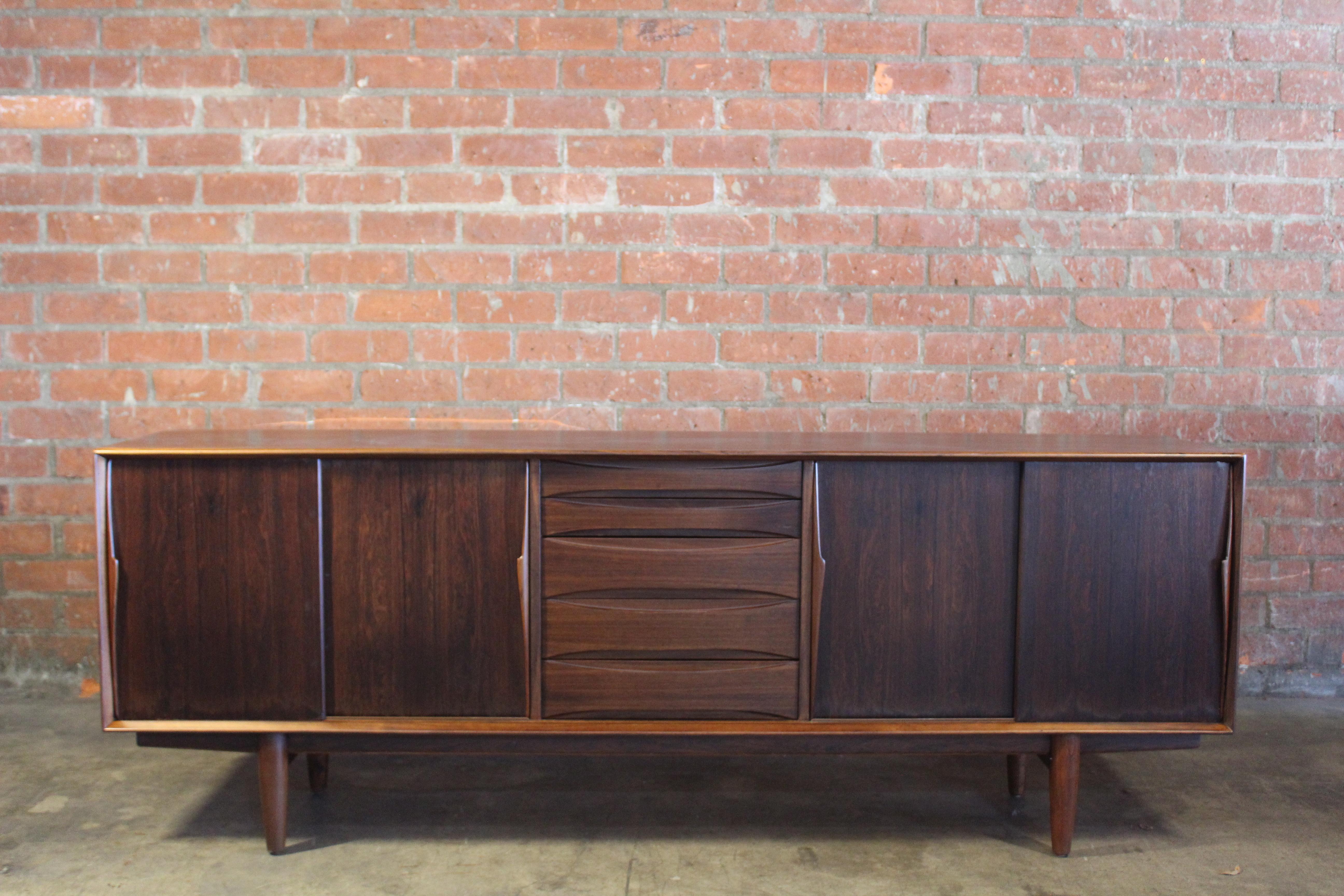 A mid-century rosewood credenza designed by Arne Vodder, Denmark, 1960s. In good condition and recently refinished and restored. Features five drawers, sliding doors and adjustable interior shelves. This piece still shows some minor wear, mostly on