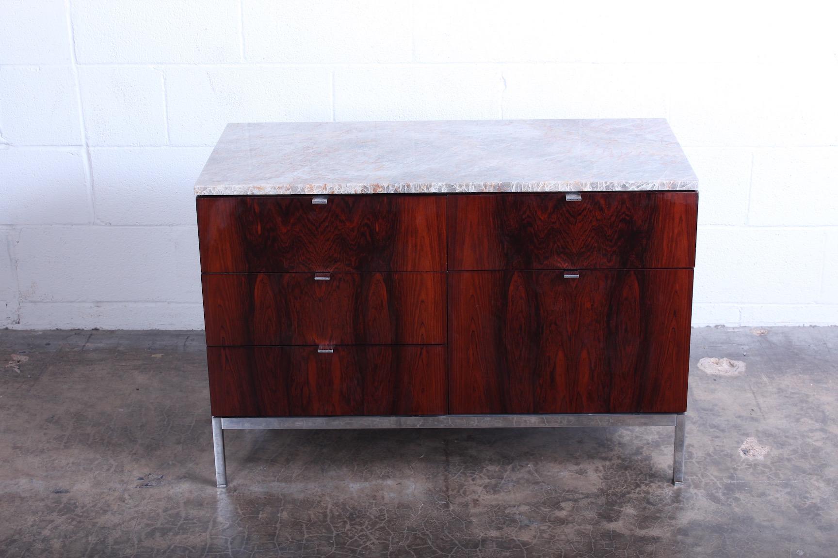 A rosewood credenza with chrome base and marble top. Designed by Florence Knoll for Knoll.
 
