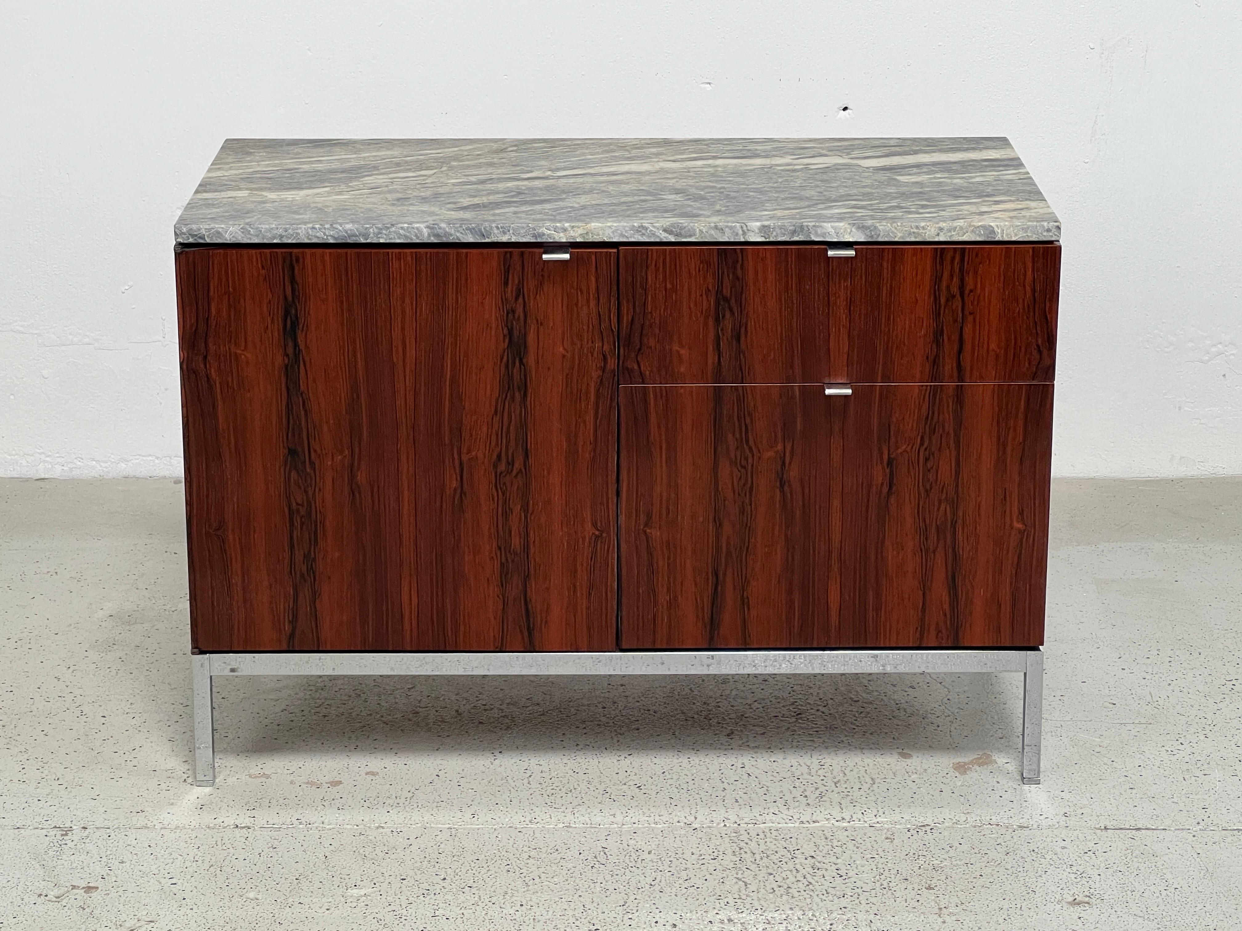 A rosewood credenza with marble top. Designed by Florence Knoll for Knoll. 