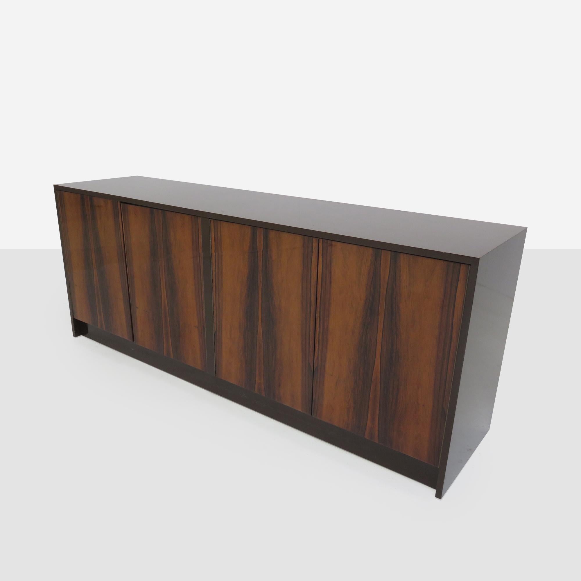 Vintage four door credenza features a beautiful grain, rosewood body and a shiny lacquered finish . There are 2 interior sliding drawers and 2 shelves.