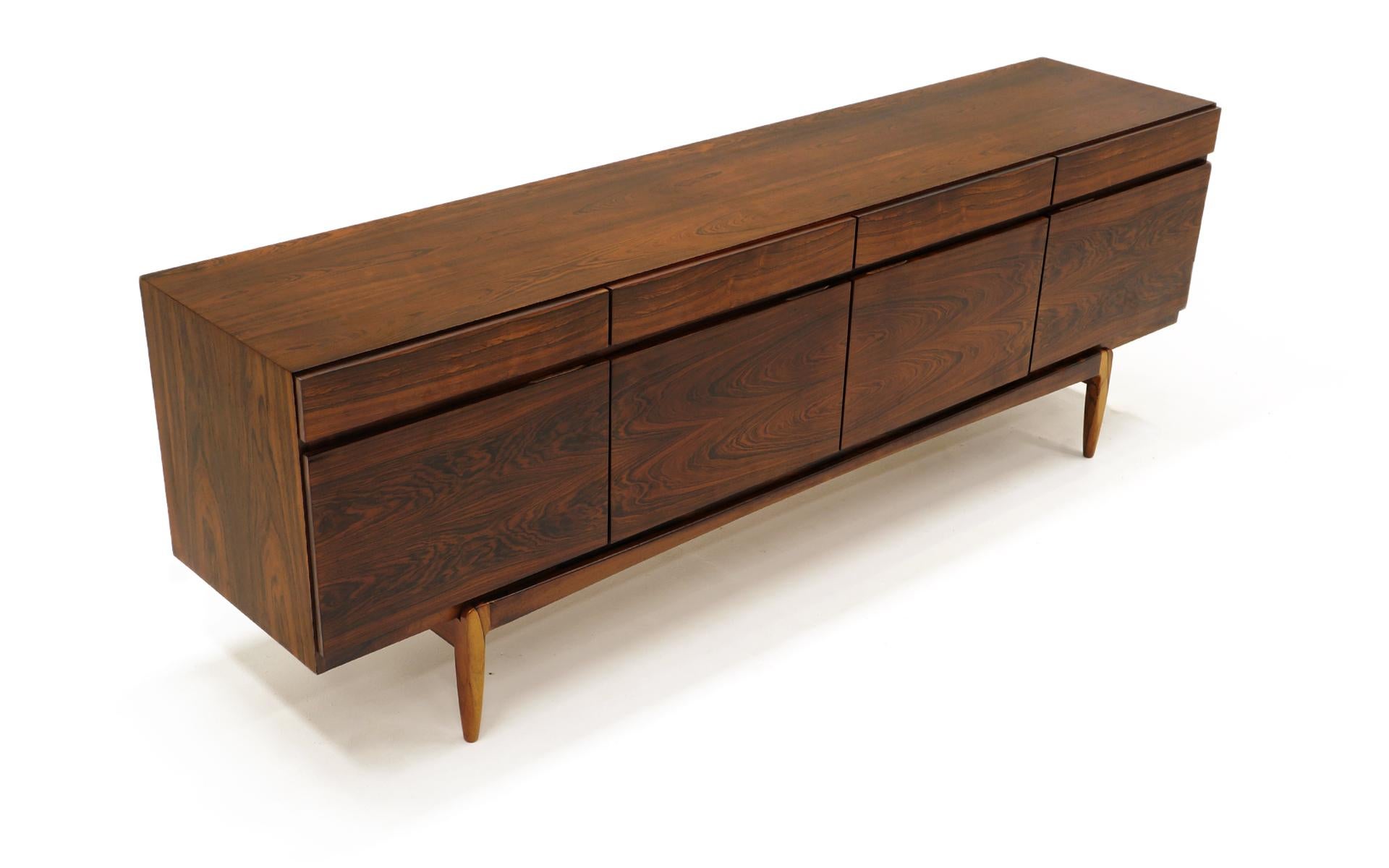 Stunning Danish Modern Kofod Larsen for Faarup Møbelfabrik sideboard or credenza model FA66 in Brazilian rosewood. Excellent design with four doors and four drawers directly above those. The inside contains two shelves and one drawer unit featuring