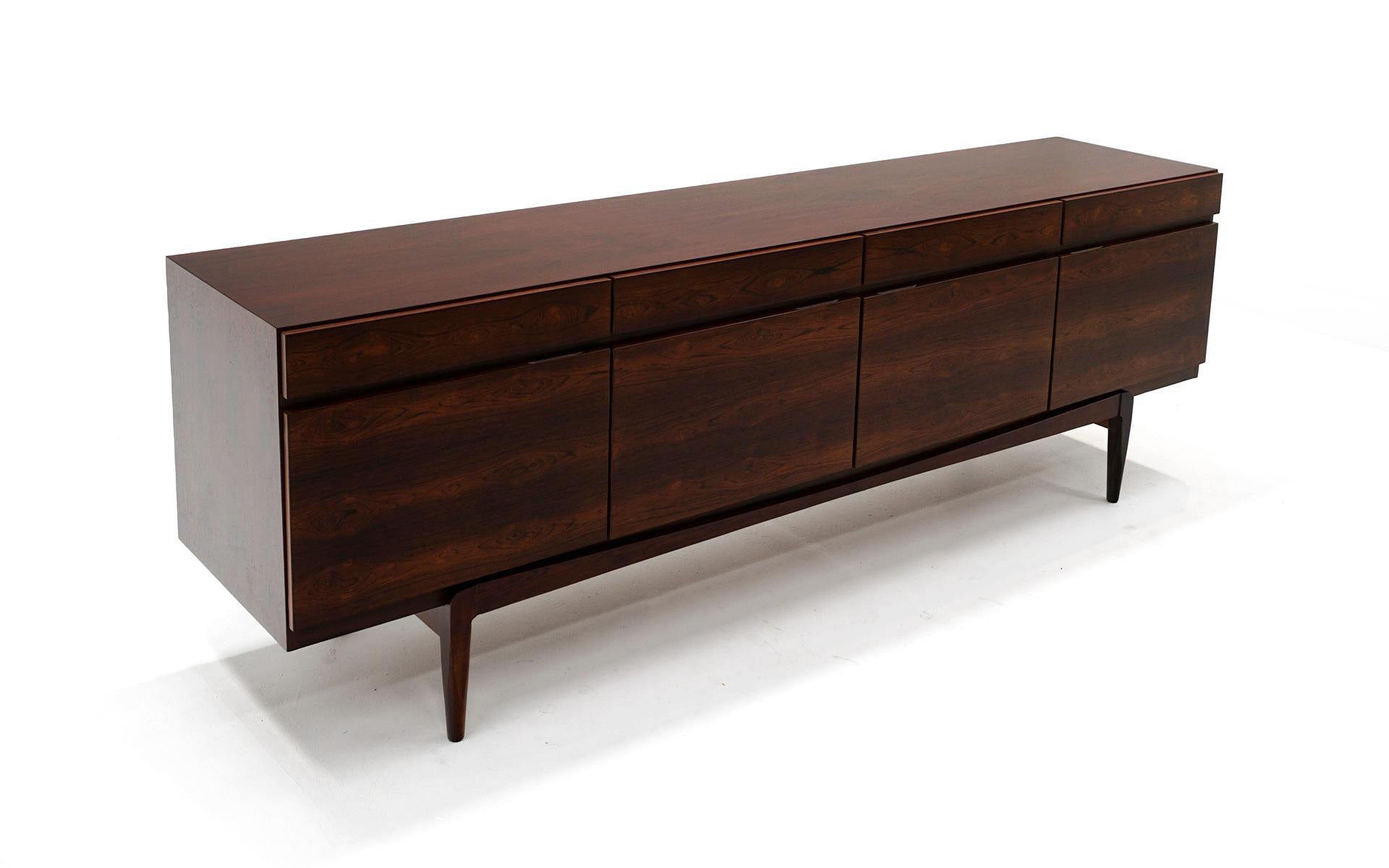 Stunning Danish Modern Kofod Larsen for Faarup Møbelfabrik sideboard / credenza / media cabinet model FA66 in Brazilian rosewood. Excellent design with four doors and four drawers directly above those. The inside contains adjustable shelves and