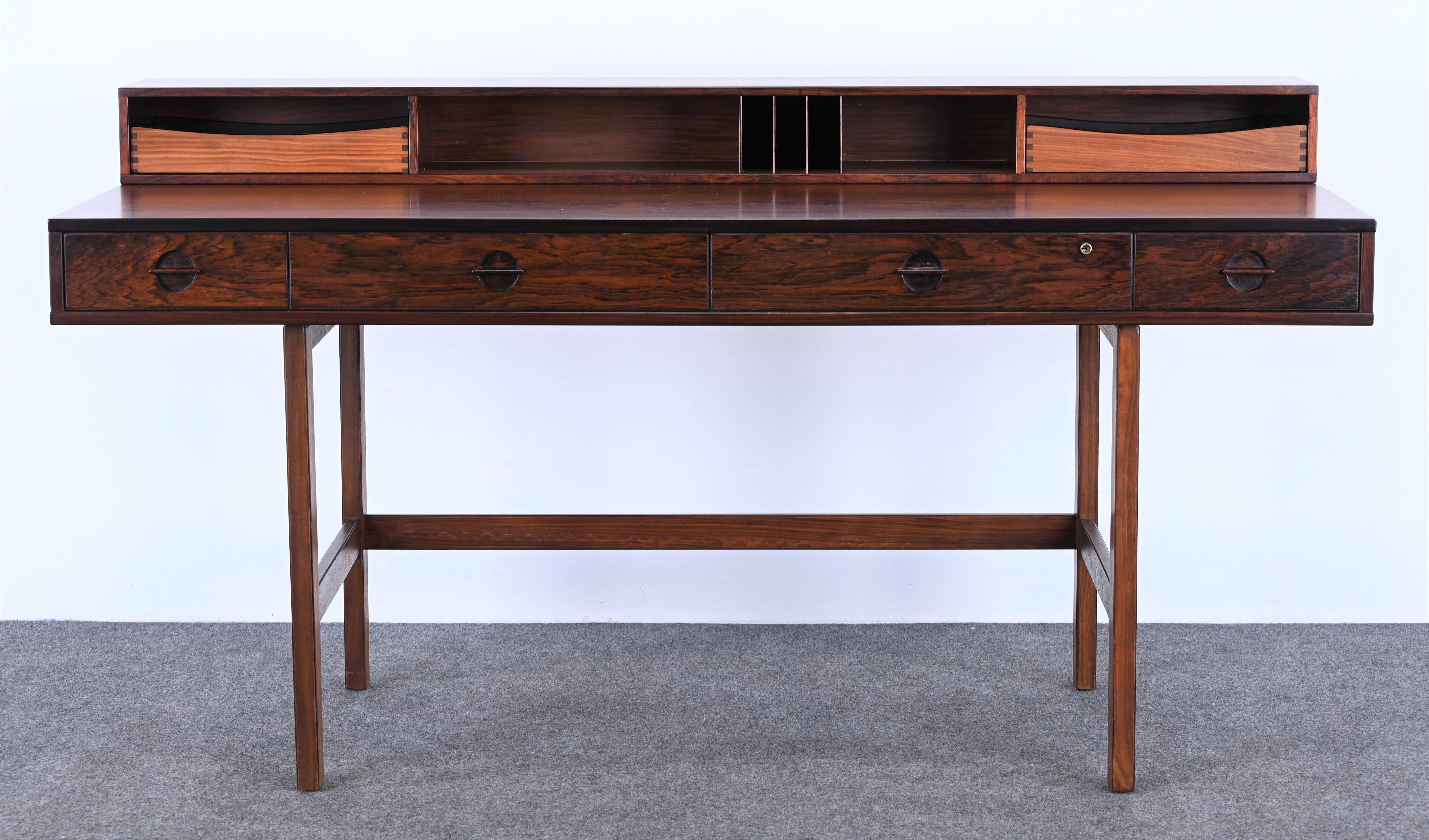 A beautiful expandable Danish Modern rosewood partners desk with a flip-top design by Jens Quistgaard for Peter Lovig Nielsen. This desk can be used either flipped down for expansive space or flipped up for ample storage. Solid rosewood construction