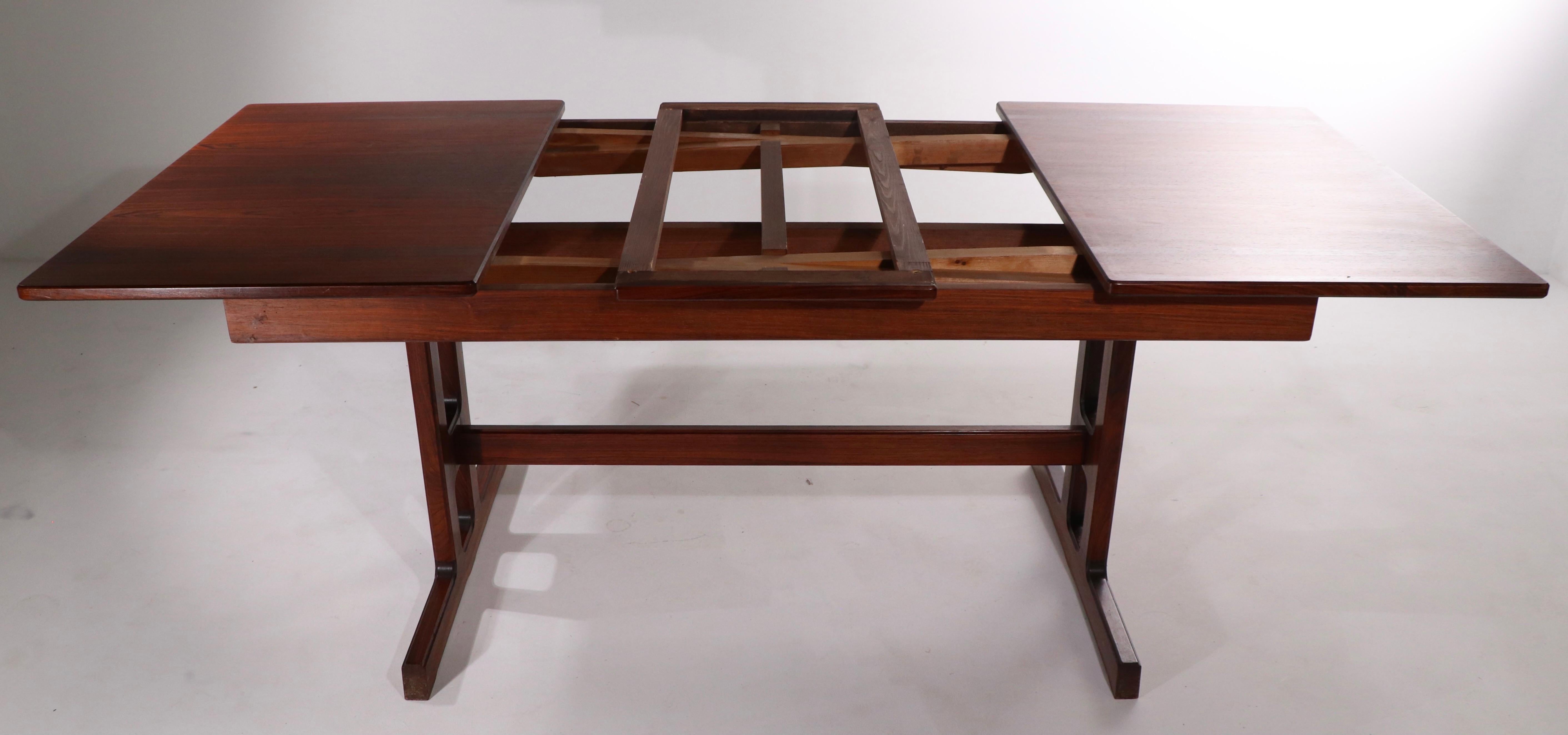 Excepcional mesa de comedor de palisandro, con una base de estilo trenza y dos grandes hojas de estilo refractario. 
La mesa está en muy buen estado, original, y sólo presenta un ligero desgaste cosmético, normal y acorde con la edad. La superficie
