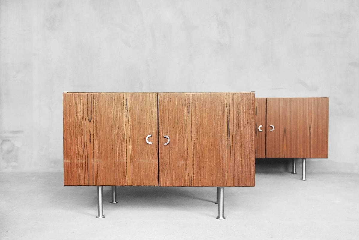 This set of two sideboards was manufactured in Denmark during the 1970s. The sideboards are veneered in three varieties of precious rosewood and have two doors with circular handles and steel legs. This set is in original condition.
