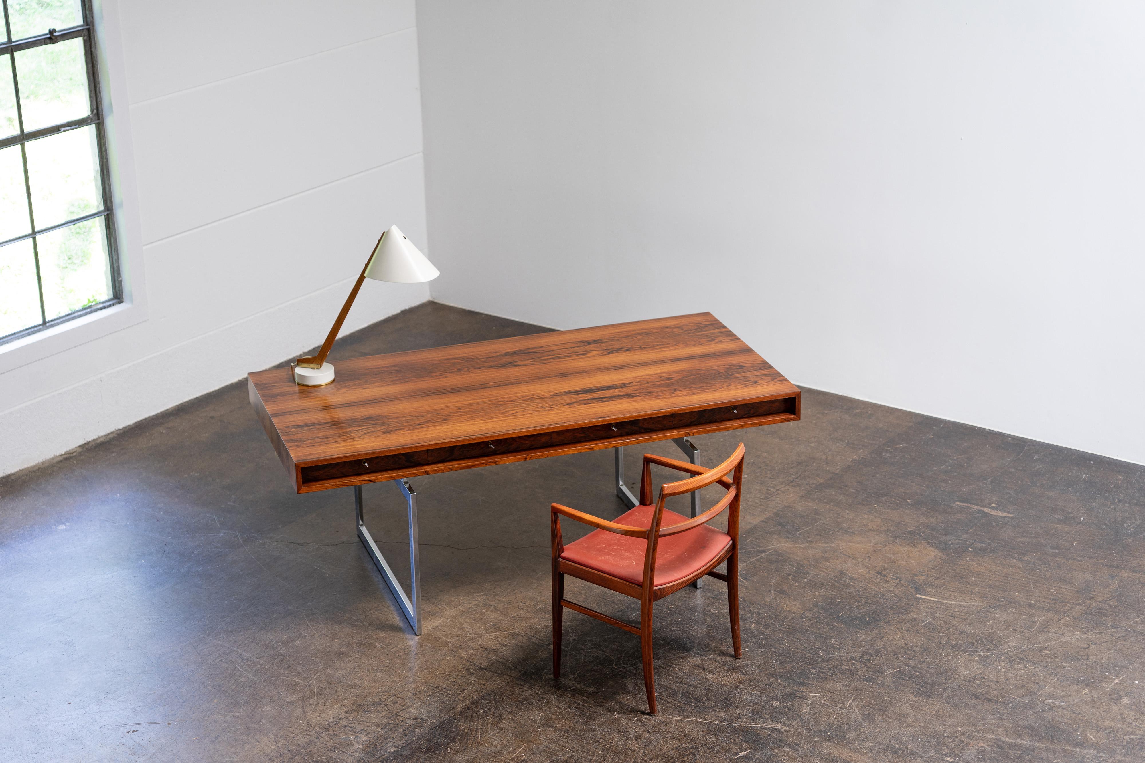 Freestanding desk by Bodil Kjaer, model 901, crafted from fine rosewood with a chrome-plated metal frame. Produced by E. Pedersen & Søn in Denmark, this desk features a cassette top with four drawers, retains its original label, and comes with all