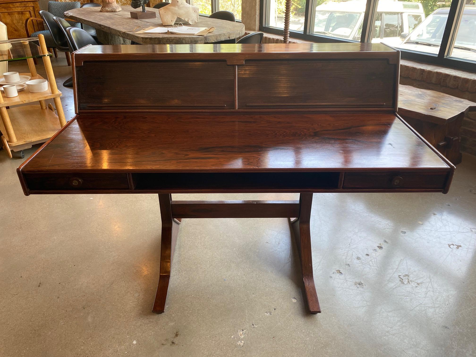 Gianfranco Frattini rosewood desk model 530, designed and manufactured by Bernini, Italy 1957. This desk is made of nicely grained rosewood and cherrywood veneer and is finished on all sides.  Well crafted tambour door storage units sit atop the