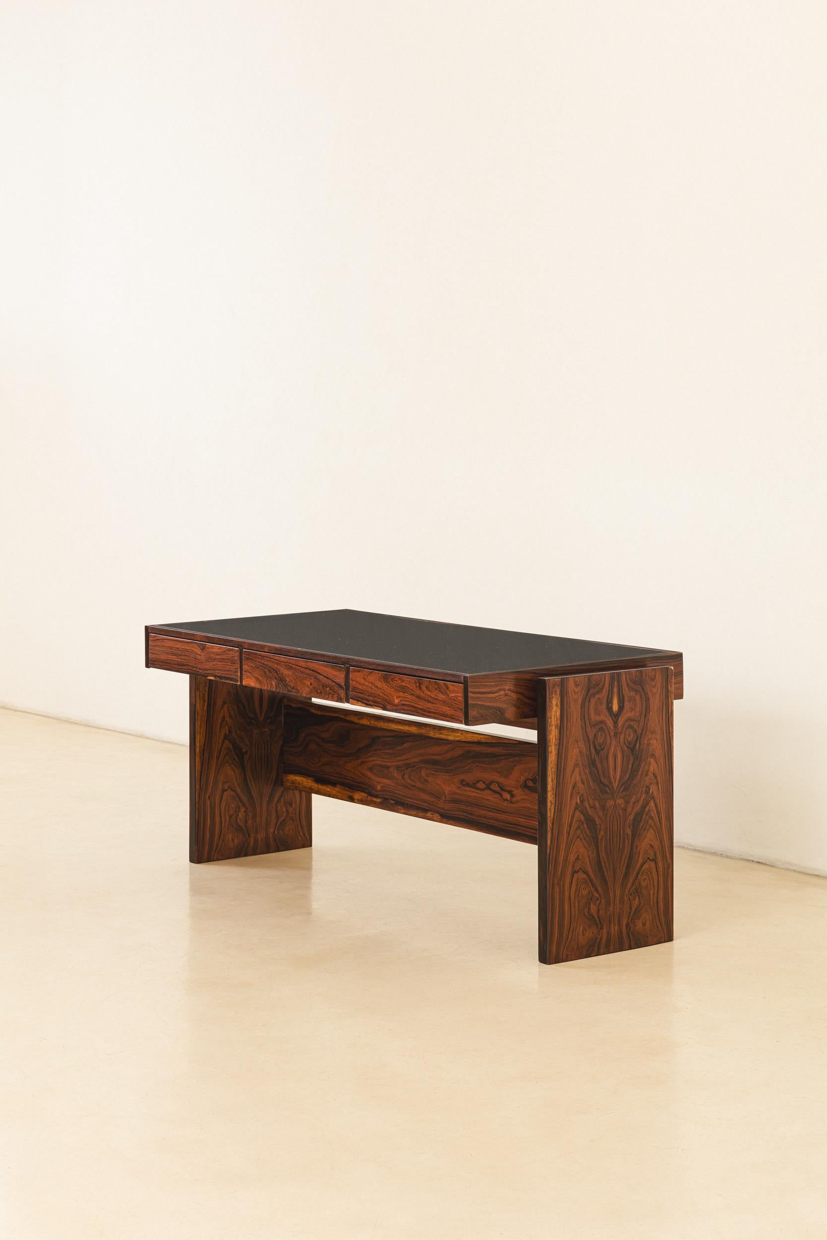 This exquisitely crafted Rosewood Desk designed by Joaquim Tenreiro (1906-1992) belonged to BLOCH EDITORES S.A. BUILDING, a Brazilian publisher founded in 1952 and closed in 2000, where Tenreiro furnished the interior.

The desk is composed of a