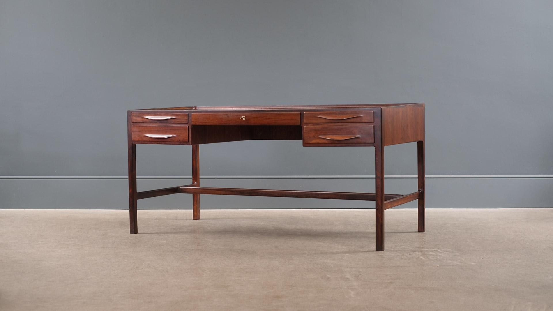 Amazing desk in beautifully figured rosewood with fabulous details designed by Kurt Ostervig for Jason, Denmark. One of the most sought after Scandinavian desks of the period. Outstanding quality throughout.