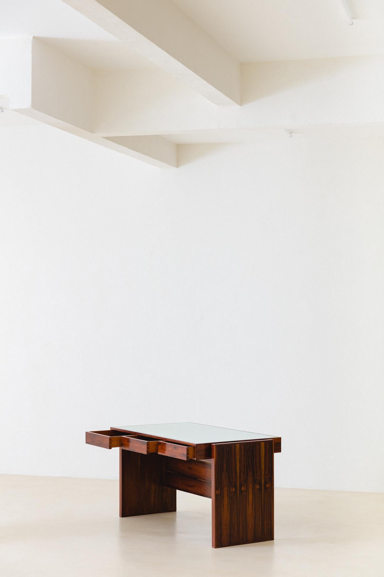 Ce bureau en bois de rose d'une qualité exceptionnelle, conçu par Joaquim Tenreiro (1906-1992), appartenait à BLOCH EDITORES S.A. BUILDING, une maison d'édition brésilienne fondée en 1952 et fermée en 2000, où Tenreiro a aménagé l'intérieur. Il