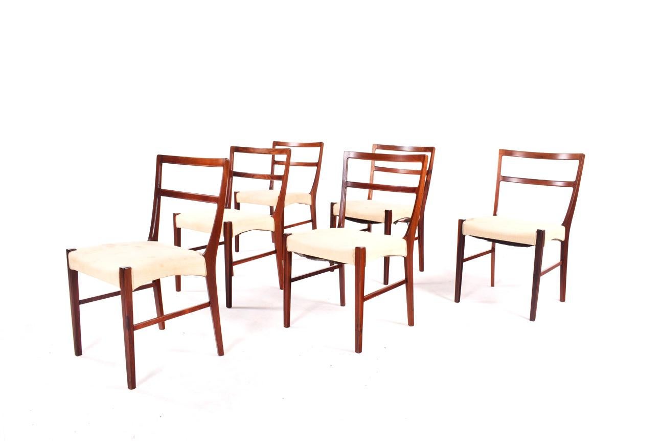 Immerse yourself in the elegance of mid-century design with this stunning set of six dining chairs, a testament to the master craftsmanship of Johannes Andersen, produced by the renowned Bernhard Pedersen & Sons in 1965. Each chair in this