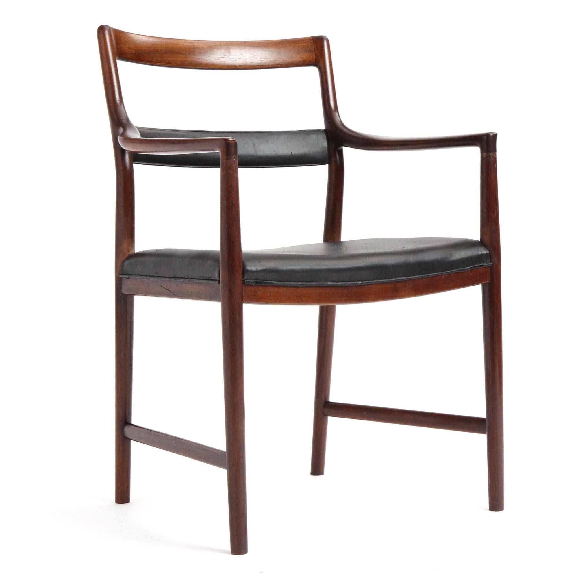 A fine, sculptural and spare group of ladder back dining chairs having luminous Brazilian rosewood frames with black leather seats and expressive leather-wrapped center slats. ?These are sold individually