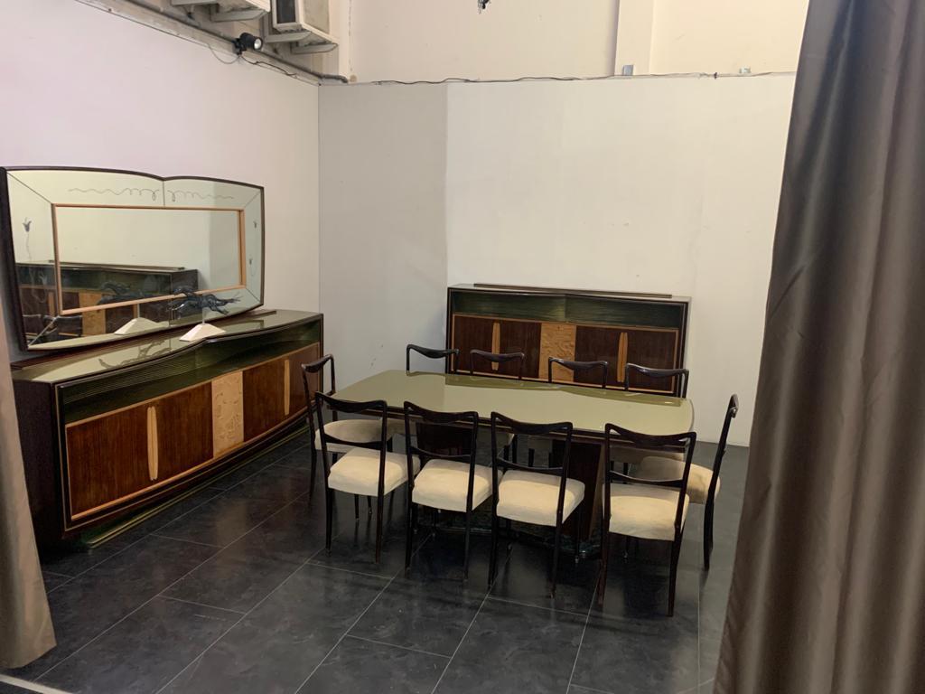 Vittorio Dassi room in rosewood with dark gold-colored glass shelves behind back shelves carved with breadstick finished in gold and green. The furniture bears finely carved panels in maple wood. To complete the table with marble base 10 chairs with