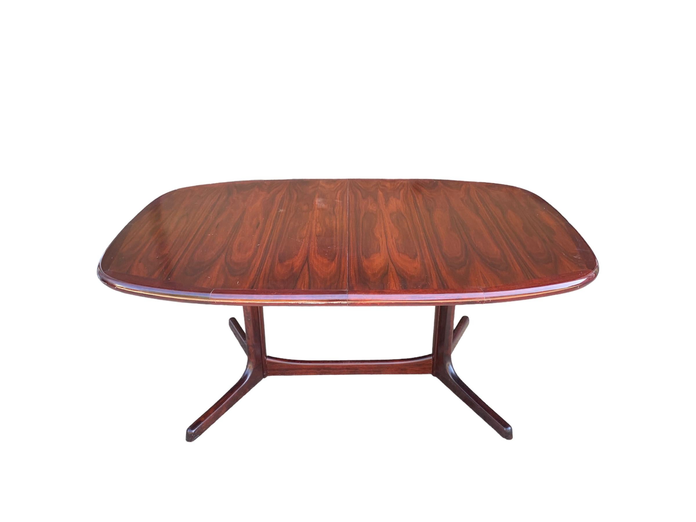 Rosewood dining table by Dyrlund of Denmark. This oval table features stunning grain and rich, even rosewood color. The table has two leaves which can add up to 40” (twenty inches each) for three different table lengths, 65”, 85” and 105”. When not