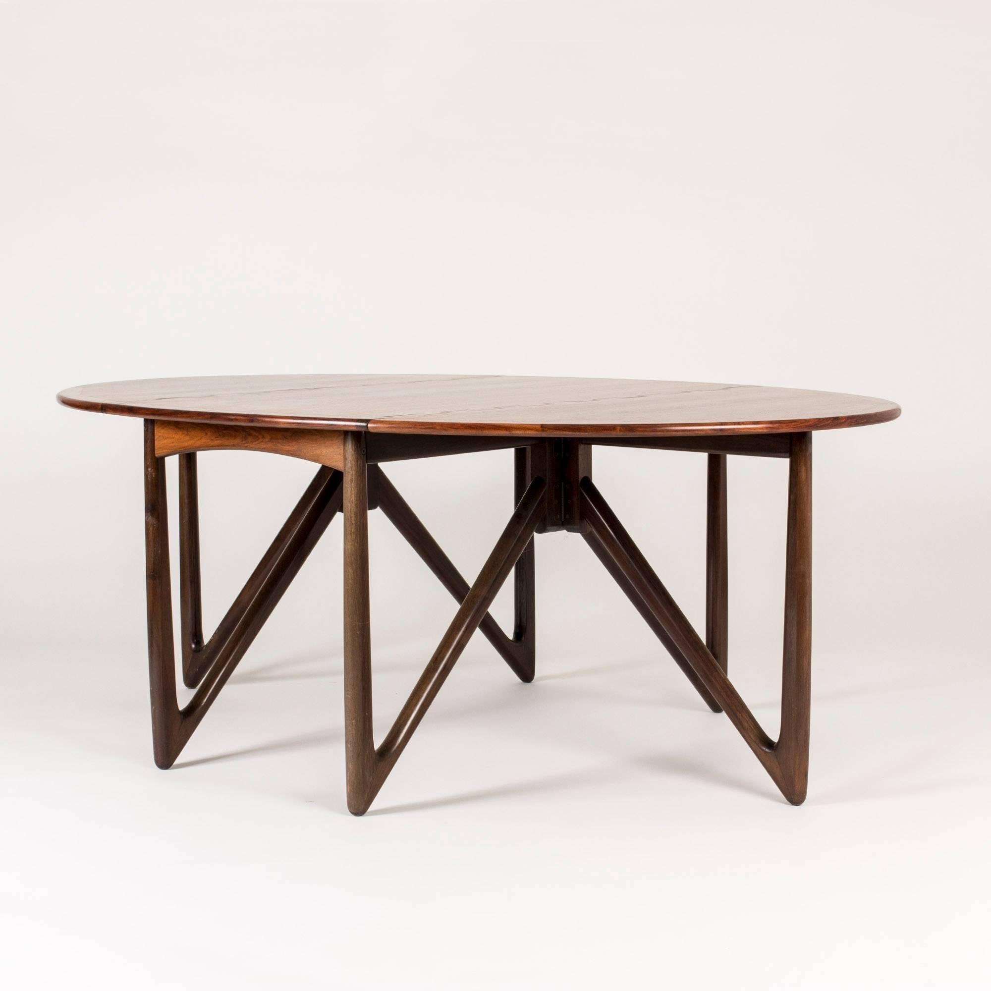 Amazing dining table by Kurt Østervig with a rosewood table top with a dramatic, contrasting pattern. Striking, V-shaped legs pick up the dramatic flair while remaining perfectly refined and functional.